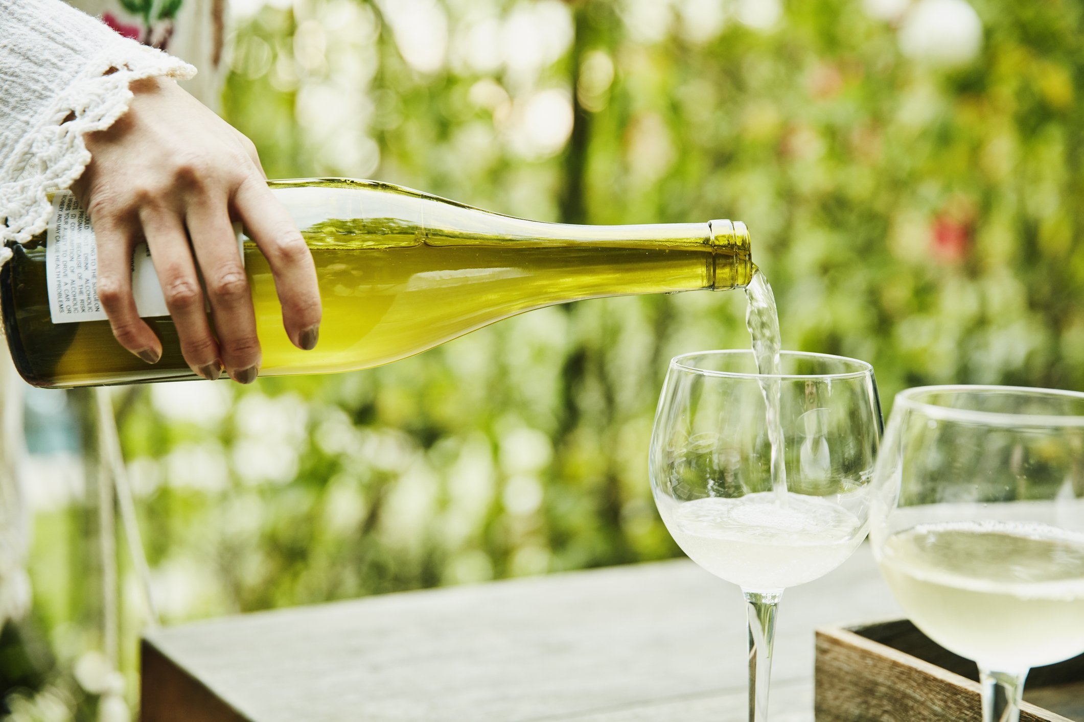 Picture of a lady pouring white wine. | Photo: Getty Images