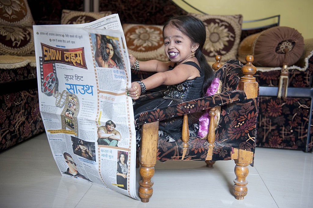 Jyoti Amge photographed reading a newspaper in Nagpur, India on December 10, 2011. | Photo: Getty Images