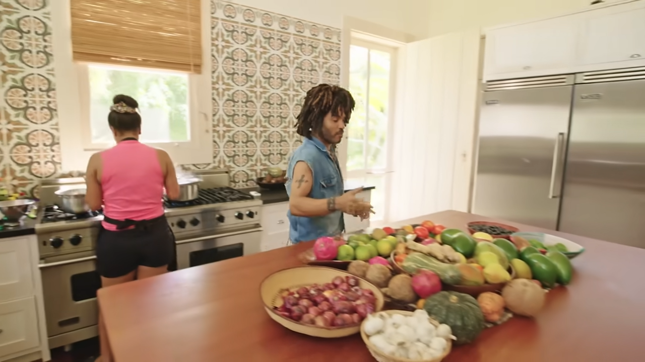 A massive, colorful mound of fresh, organic farm-to-table fruits and vegetables sits piled high across the central wooden island. | Source: YouTube/@Archdigest