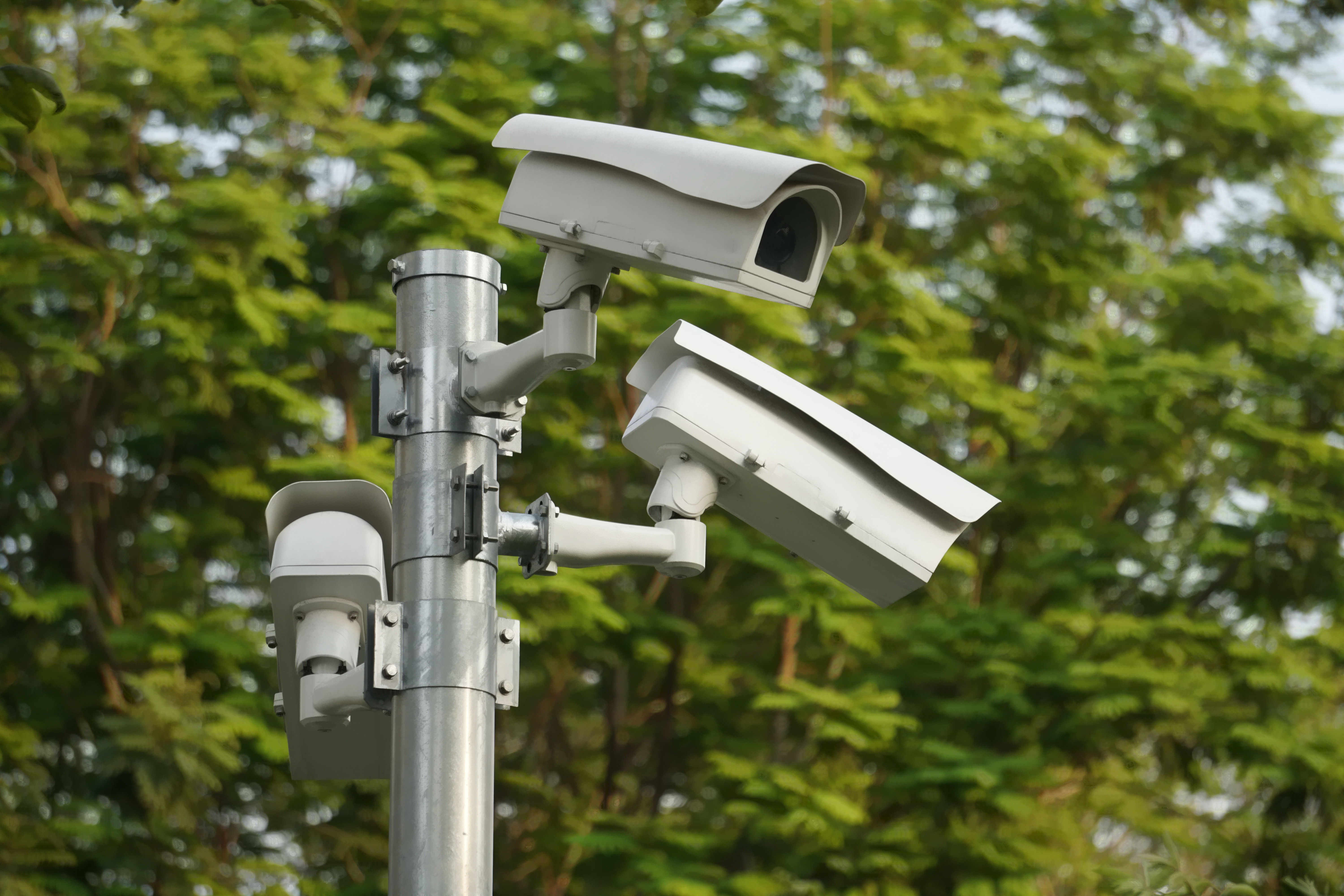 CC.TV. cameras on metal pole in public park for monitor, observe and record evident of incident for investigation and prevent criminal. | Source: Shutterstock