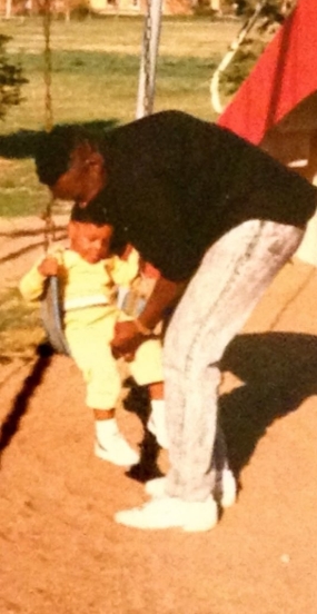 Laurence Thomaz helps a young Wiz Khalifa onto a swing in a childhood photo that surfaced in a post published on February 14, 2026. | Source: X/Poetik Flakko