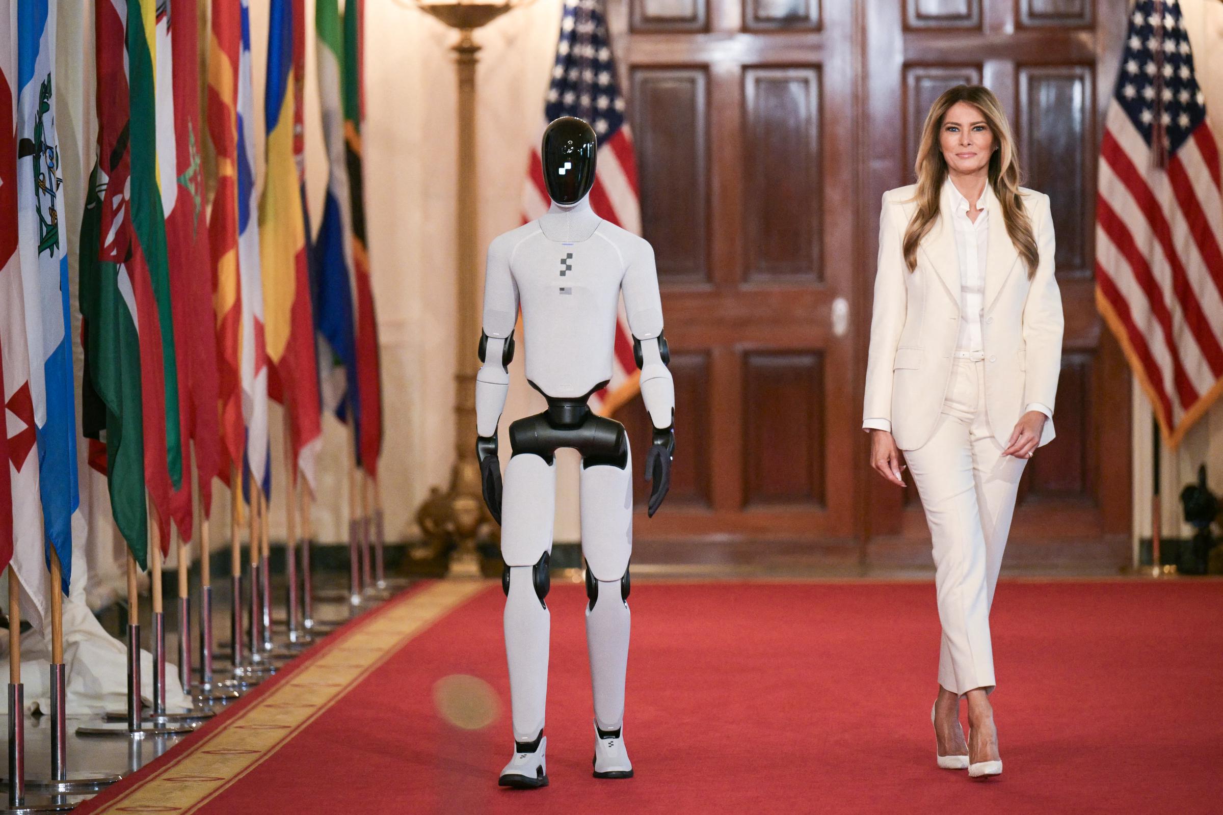 Melania Trump walks with a humanoid robot at the Global Coalition Summit at the White House on March 25, 2026. | Source: Getty Images