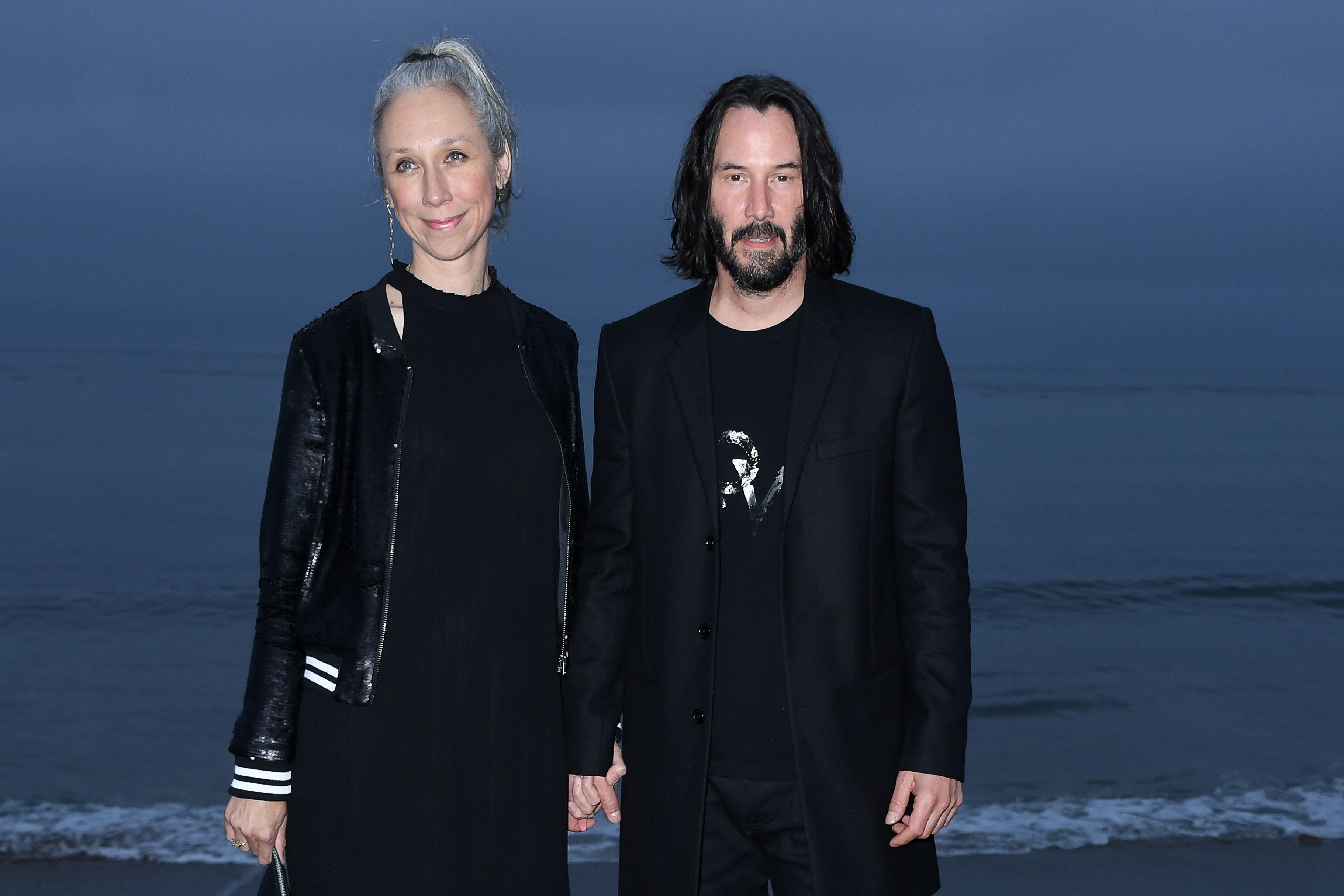 Canadian-US actor Keanu Reeves (R) and US artist Alexandra Grant arrive for the Saint Laurent Men's Spring-Summer 2020 runway show in Malibu, California, on June 6, 2019