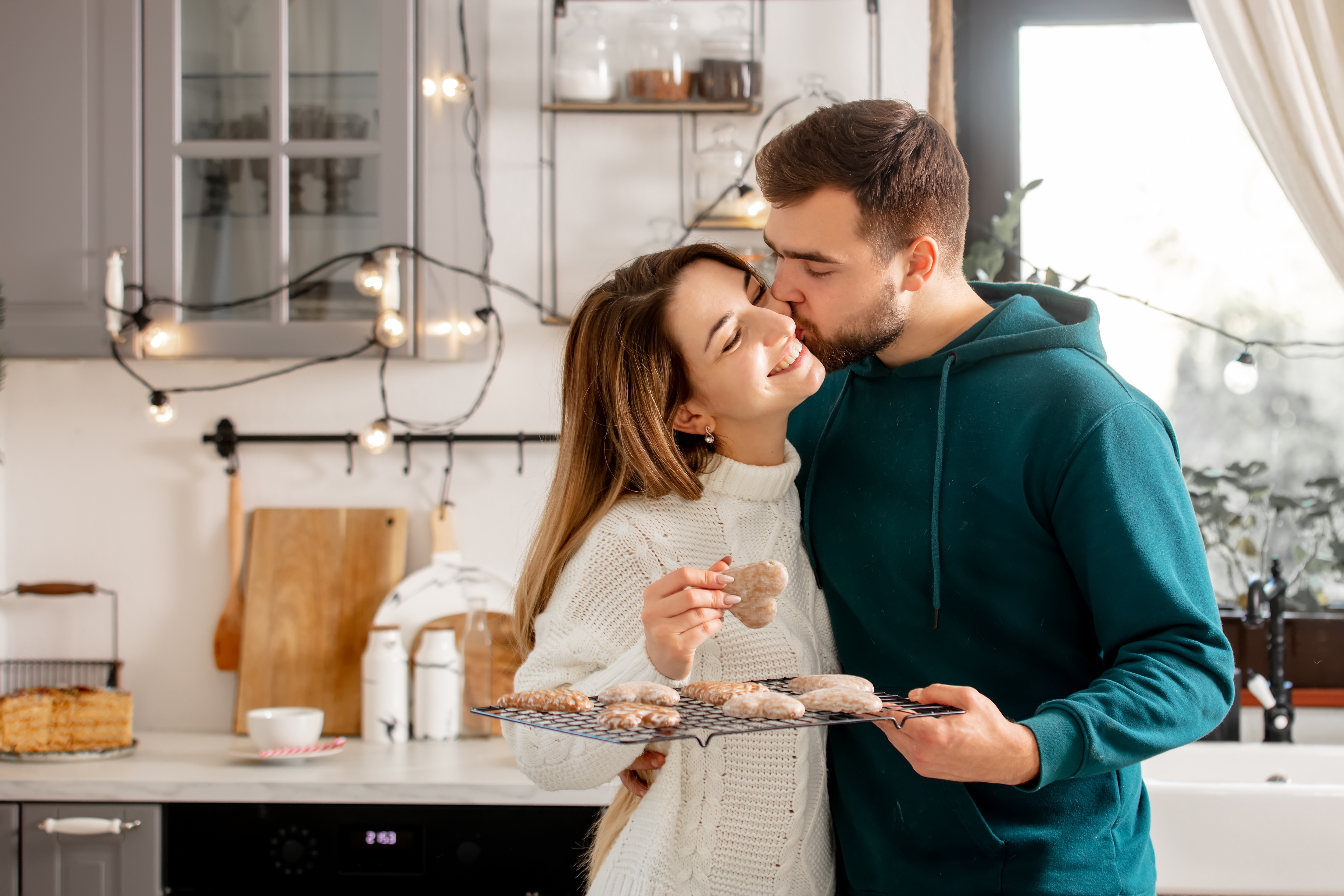 A man kissing a woman's cheek in the kitchen | Source: Shutterstock