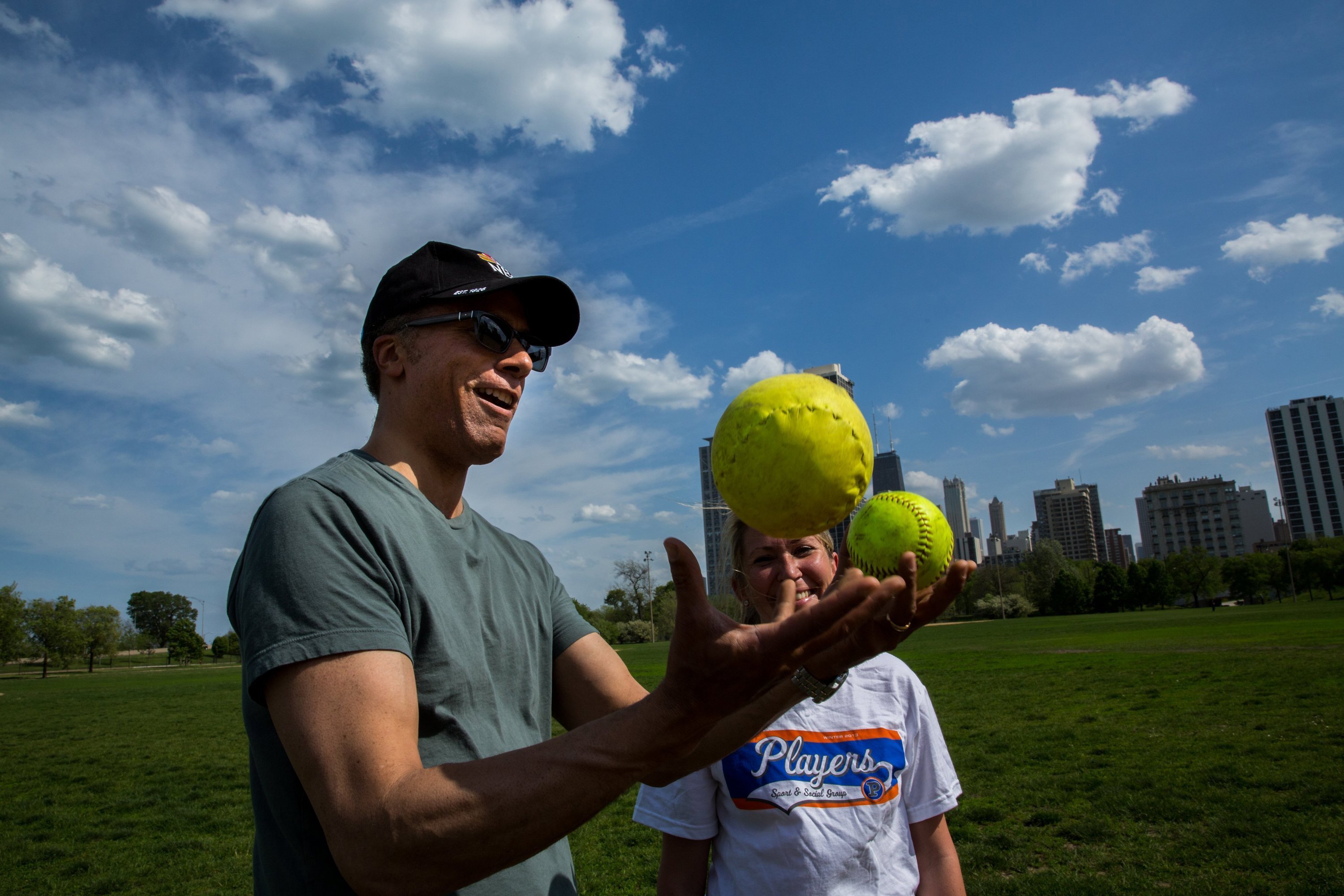 Lester Holt does some juggling after getting information about 16-inch softball vs. regular softball from Krista Scyphers as he visits softball fields in Lincoln Park, on May 20, 2013 | Source: Getty Images