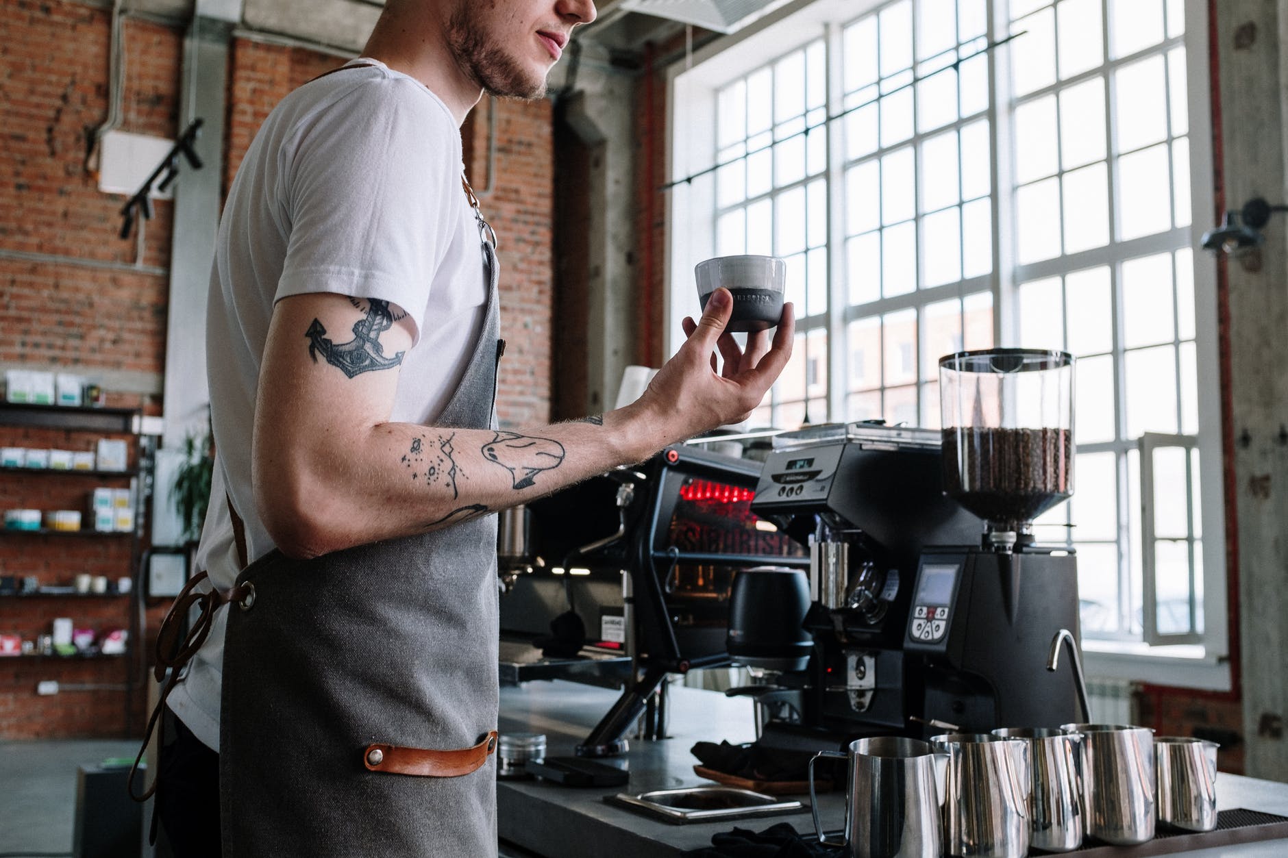 Barista con una taza de café en la mano | Foto: Pexels