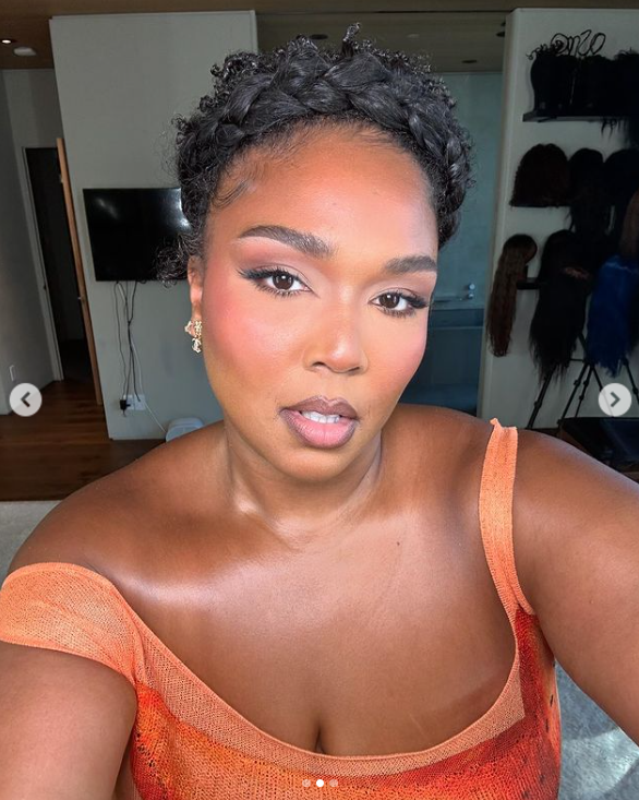 Lizzo's selfie wearing a floral-printed orange dress, posted on November 29, 2024 | Source: Instagram.com/lizzobeeating