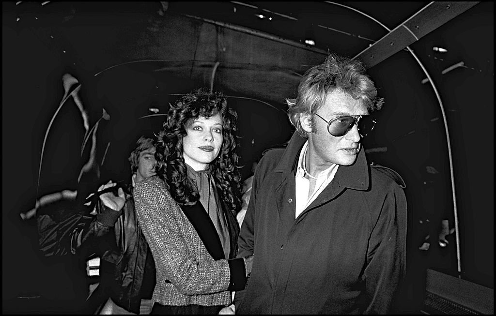 Johnny Hallyday et sa compagne Babeth Etienne à l'aéroport en 1980. | Photo : Getty Images 