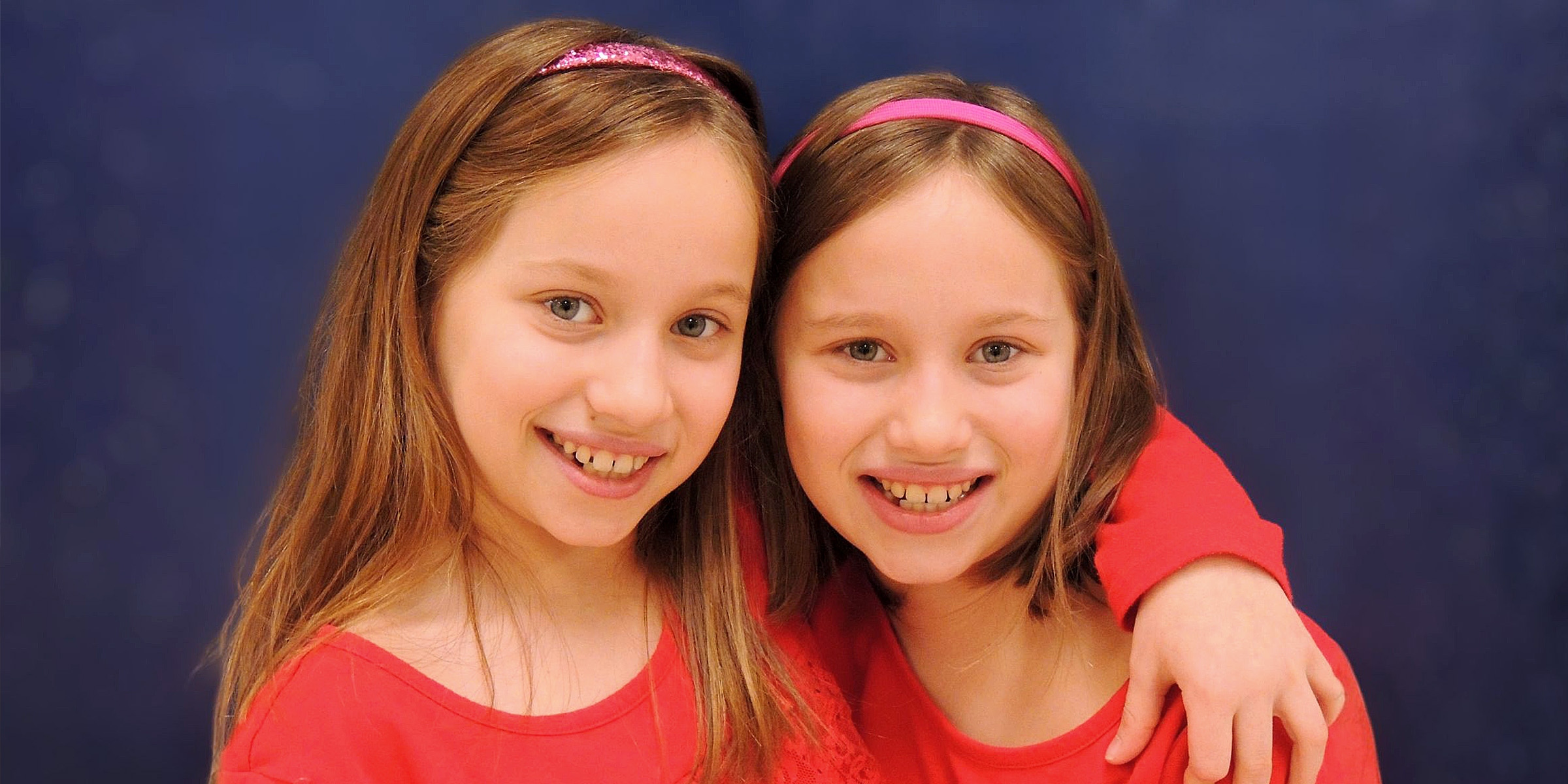 Twin girls standing together | Source: Flickr