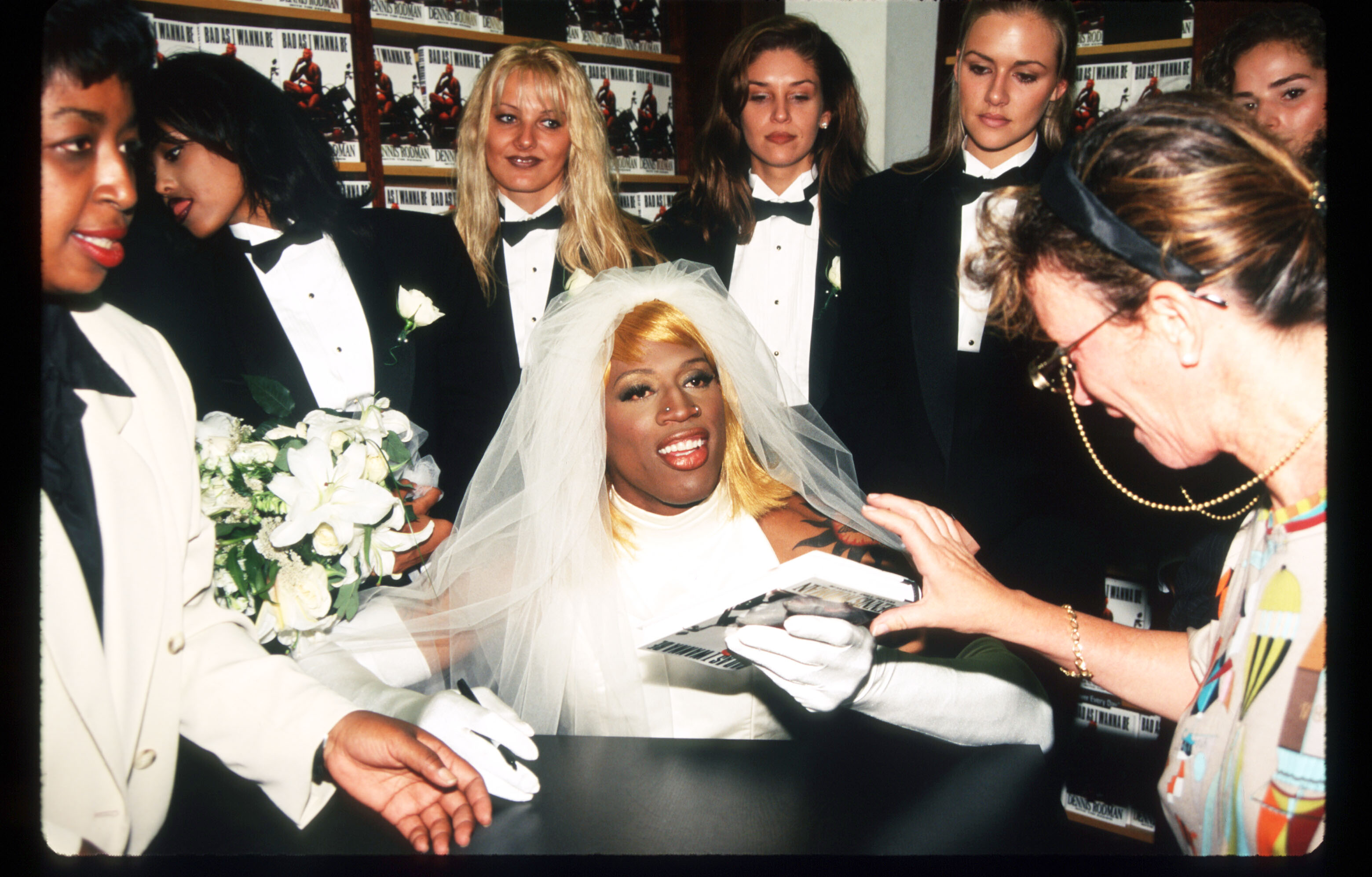 Dennis Rodman signs his autobiography August 21, 1996 in New York City. Rodman arrived in a horse-drawn carriage dressed in a wedding gown to launch his new book called "Bad as I Wanna Be." | Source: Getty Images