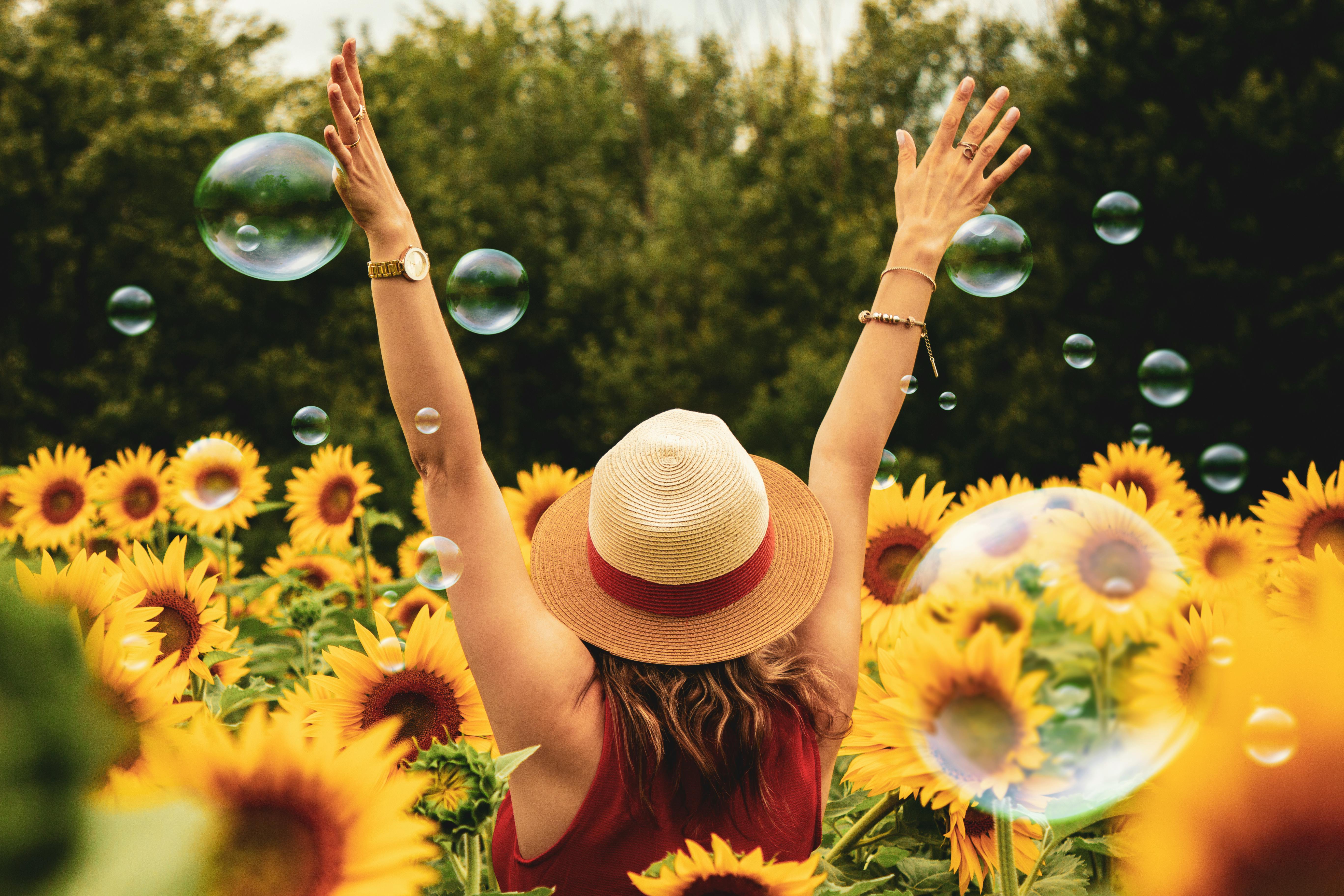 Una mujer feliz en un campo de girasoles | Fuente: Pexels