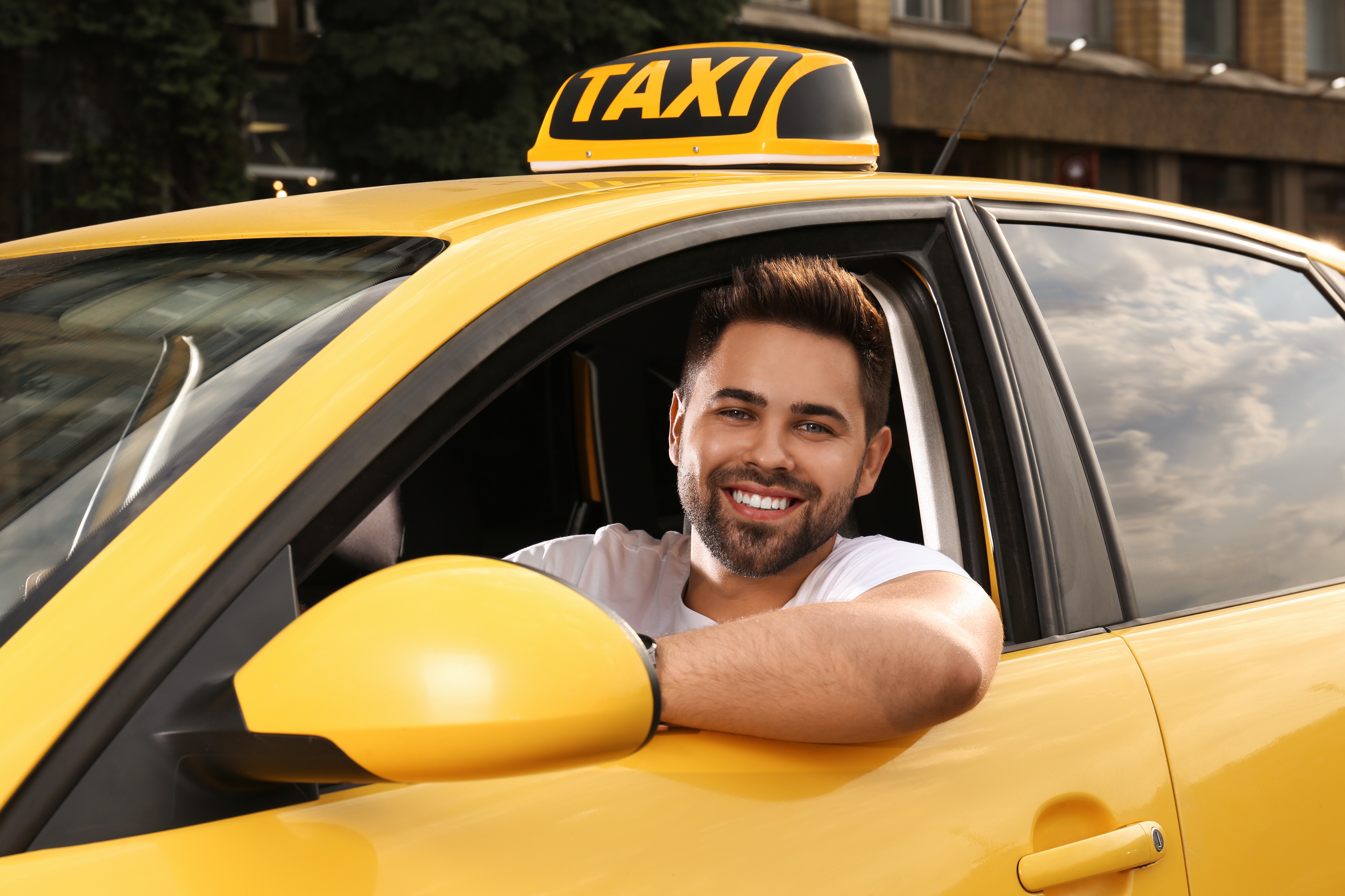 A male taxi driver in a yellow taxi | Source: Shutterstock
