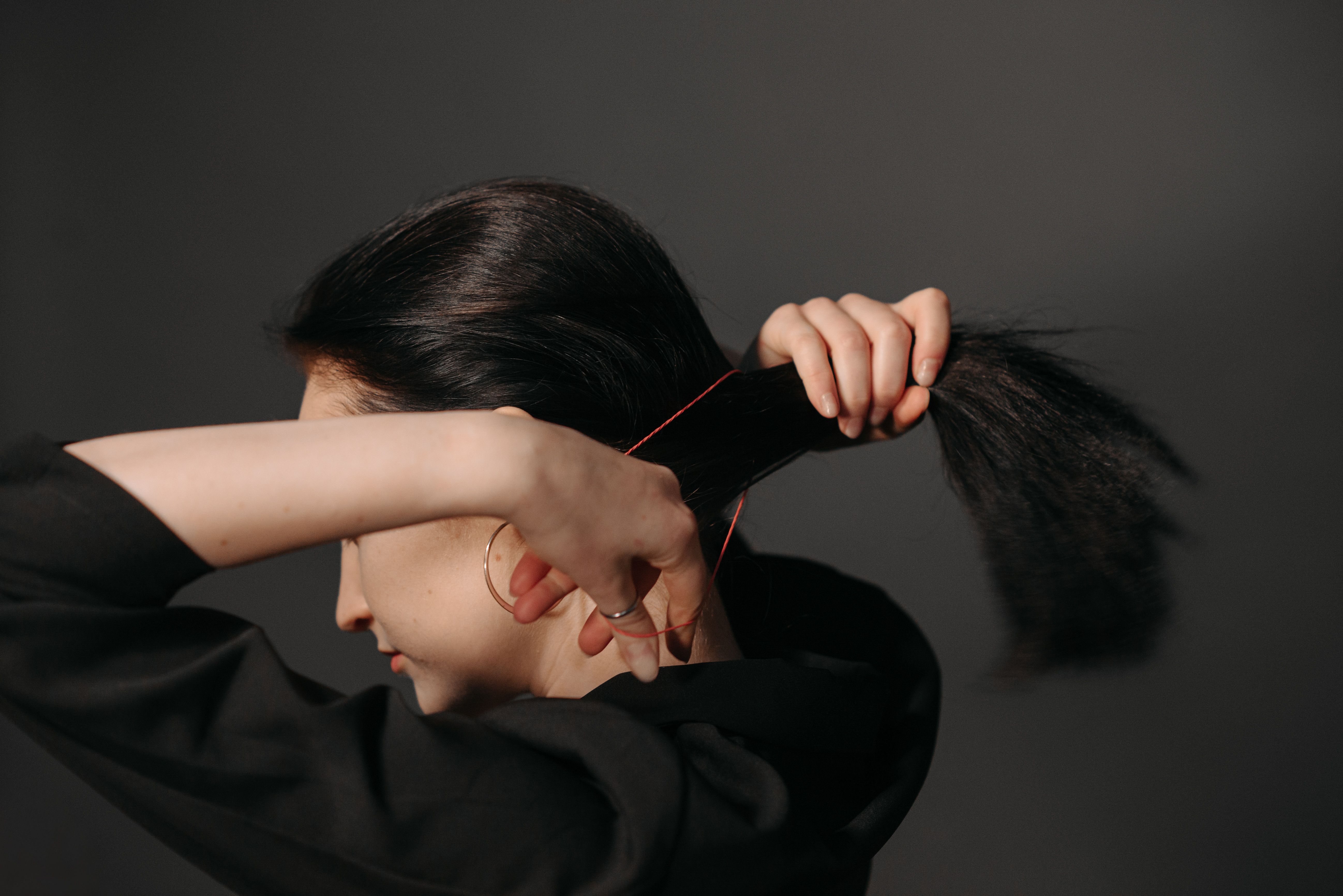 Woman tying her hair in a ponytail | Source: Pexels