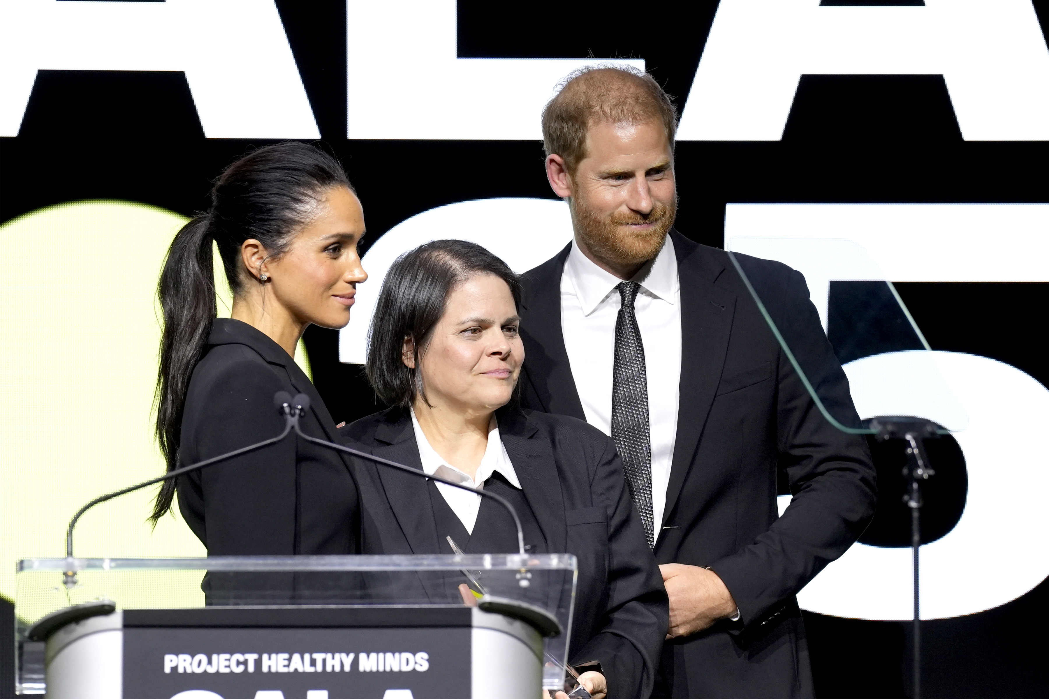 Meghan Markle and Prince Harry on stage with Laura Marquez-Garrett at Project Healthy Minds' World Mental Health Day Gala in New York City on October 9, 2025. | Source: Getty Images