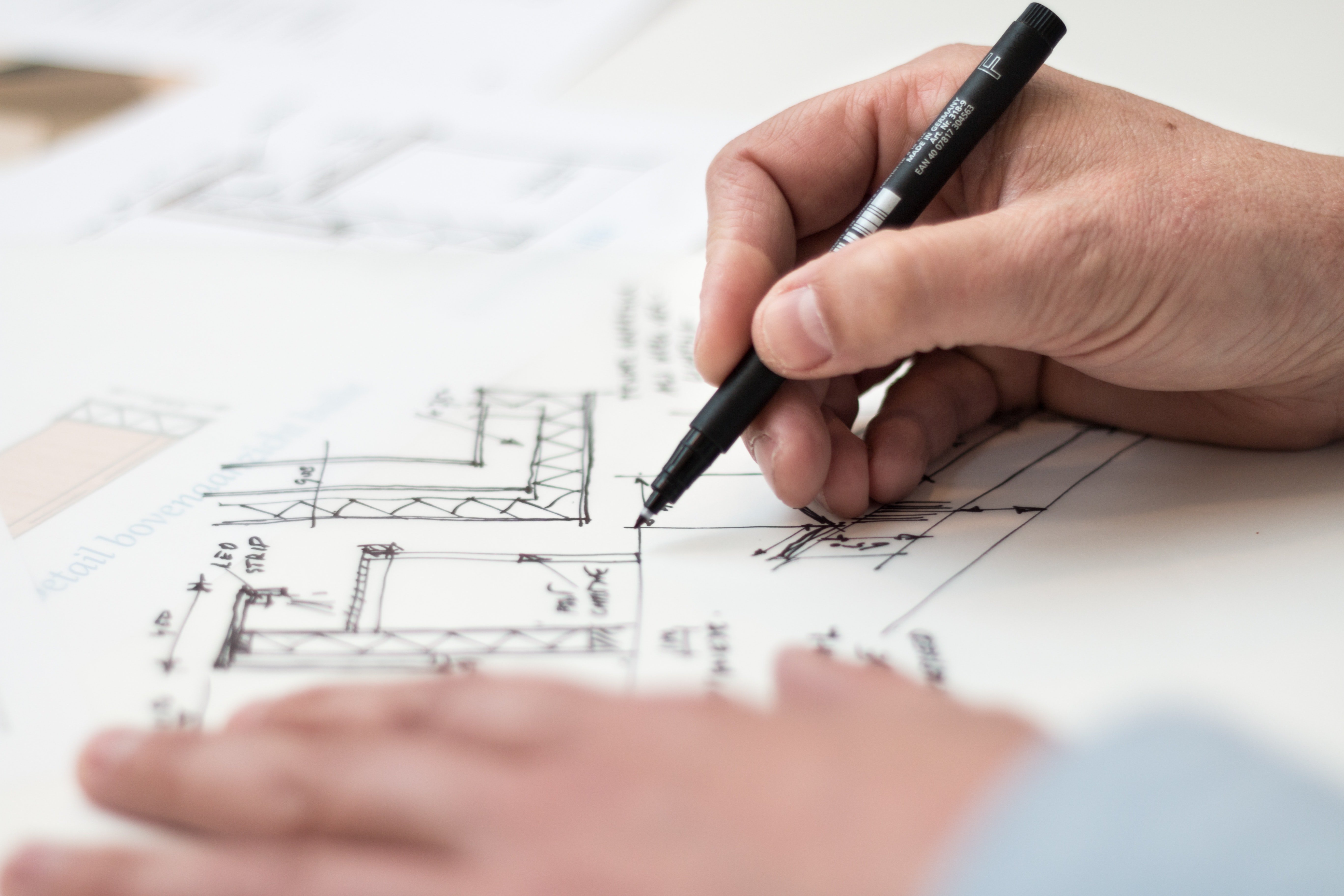 Pictured - An individual with a black pen designing a structure | Source: Pexels 
