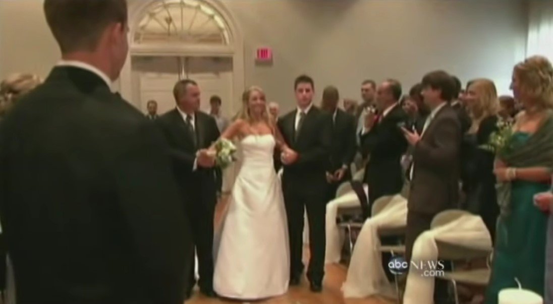 Jennifer Darmon walking down the aisle on her wedding day, with the help of her father and brother | Source: Youtube/ ABC News