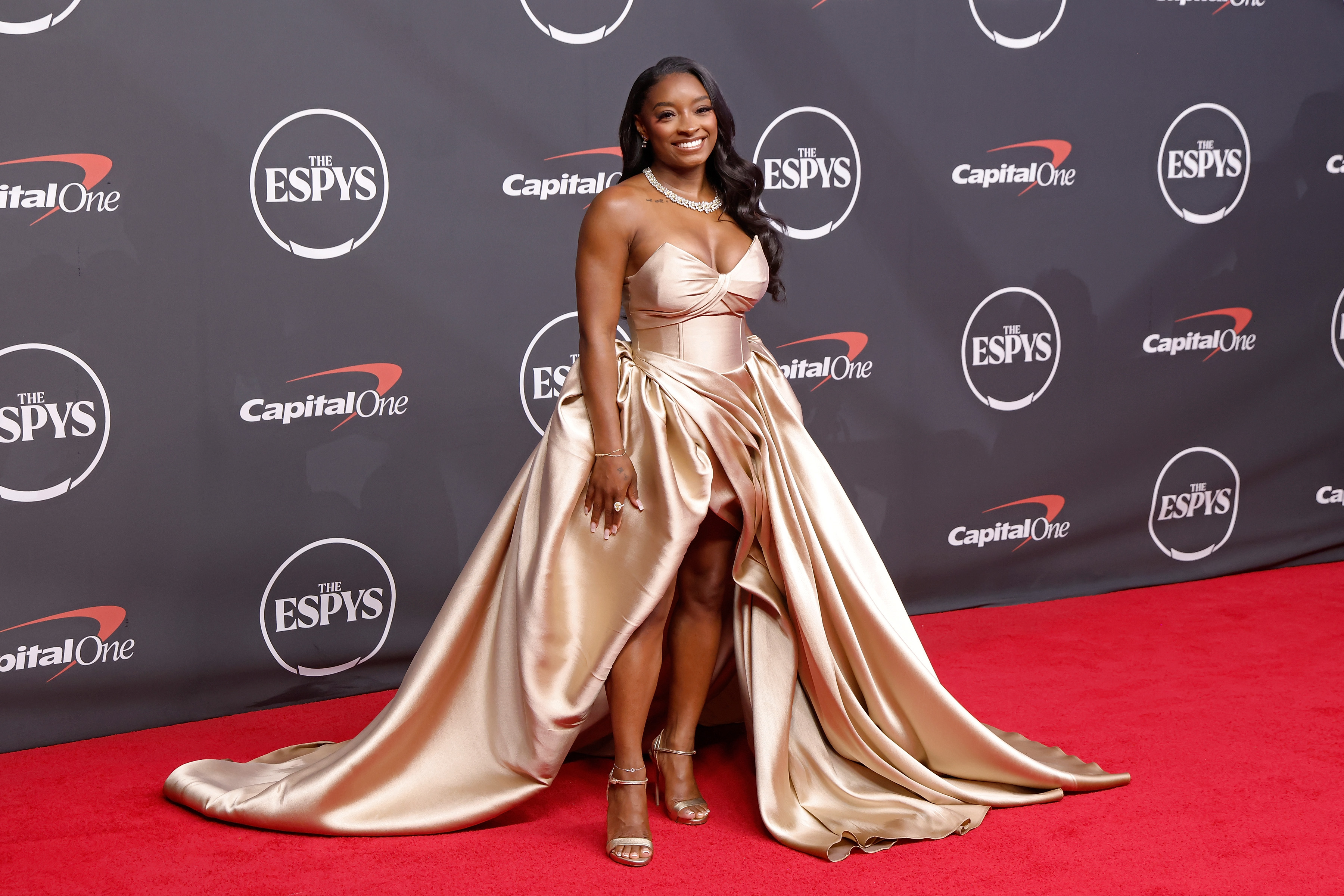 A closer look at Biles' ESPYS outfit shows the flowing silhouette and long train that made her one of the evening's most talked-about fashion figures. As reactions to the viral video remained divided, the red carpet photos kept the spotlight on her look. | Source: Getty Images