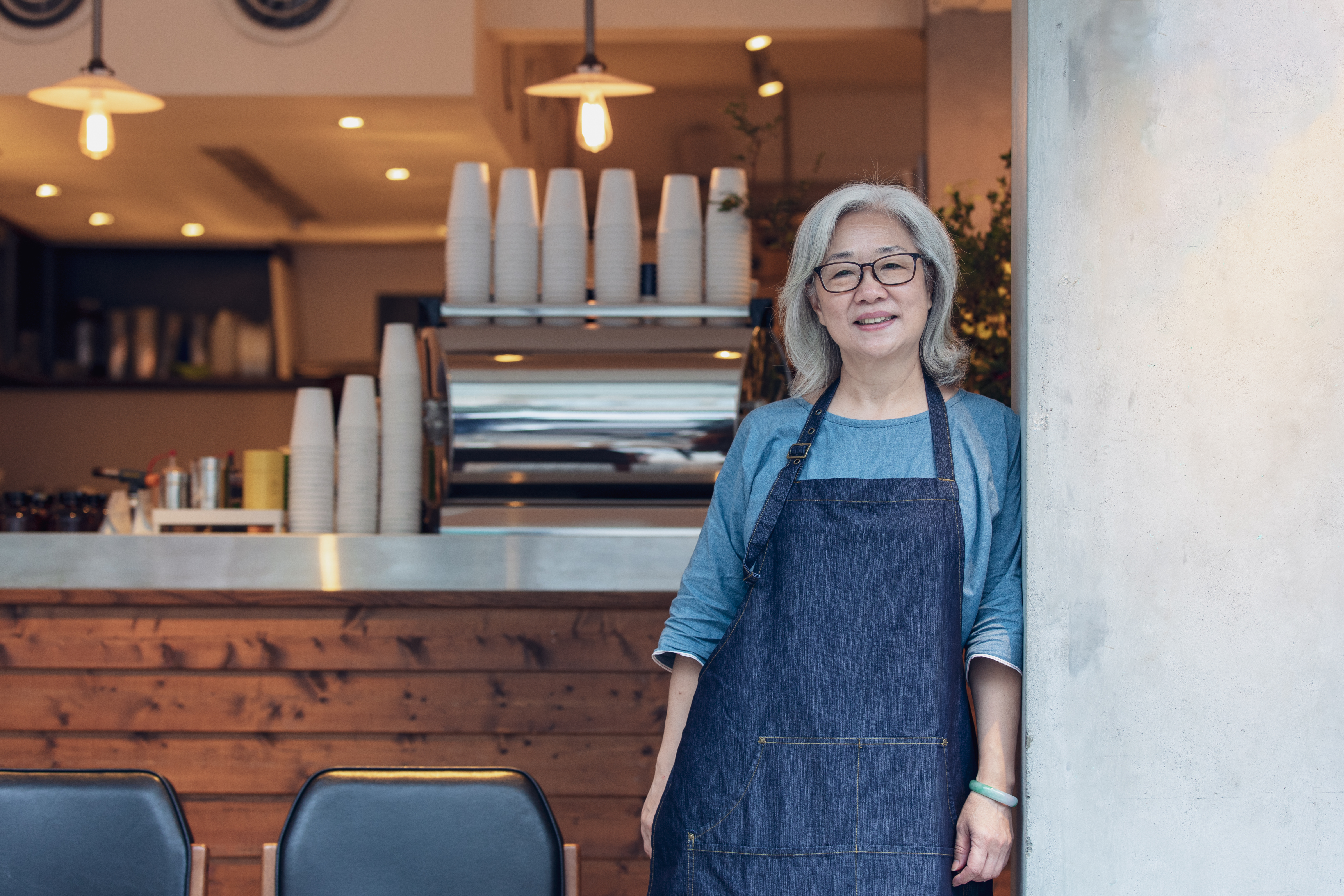 A gray-haired woman standing inside a coffee shop | Source: Getty Images
