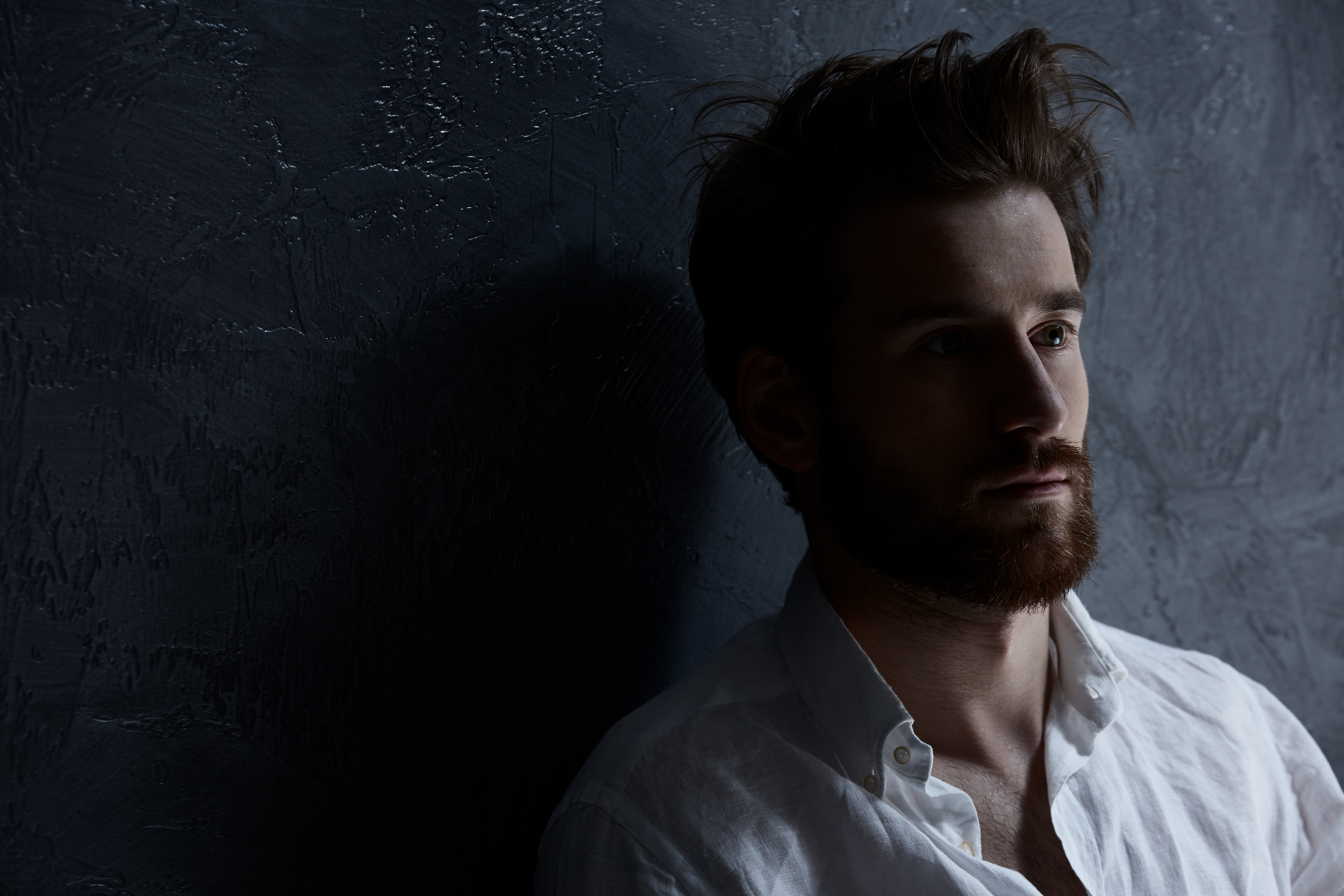 A distraught man standing against a wall | Source: Shutterstock