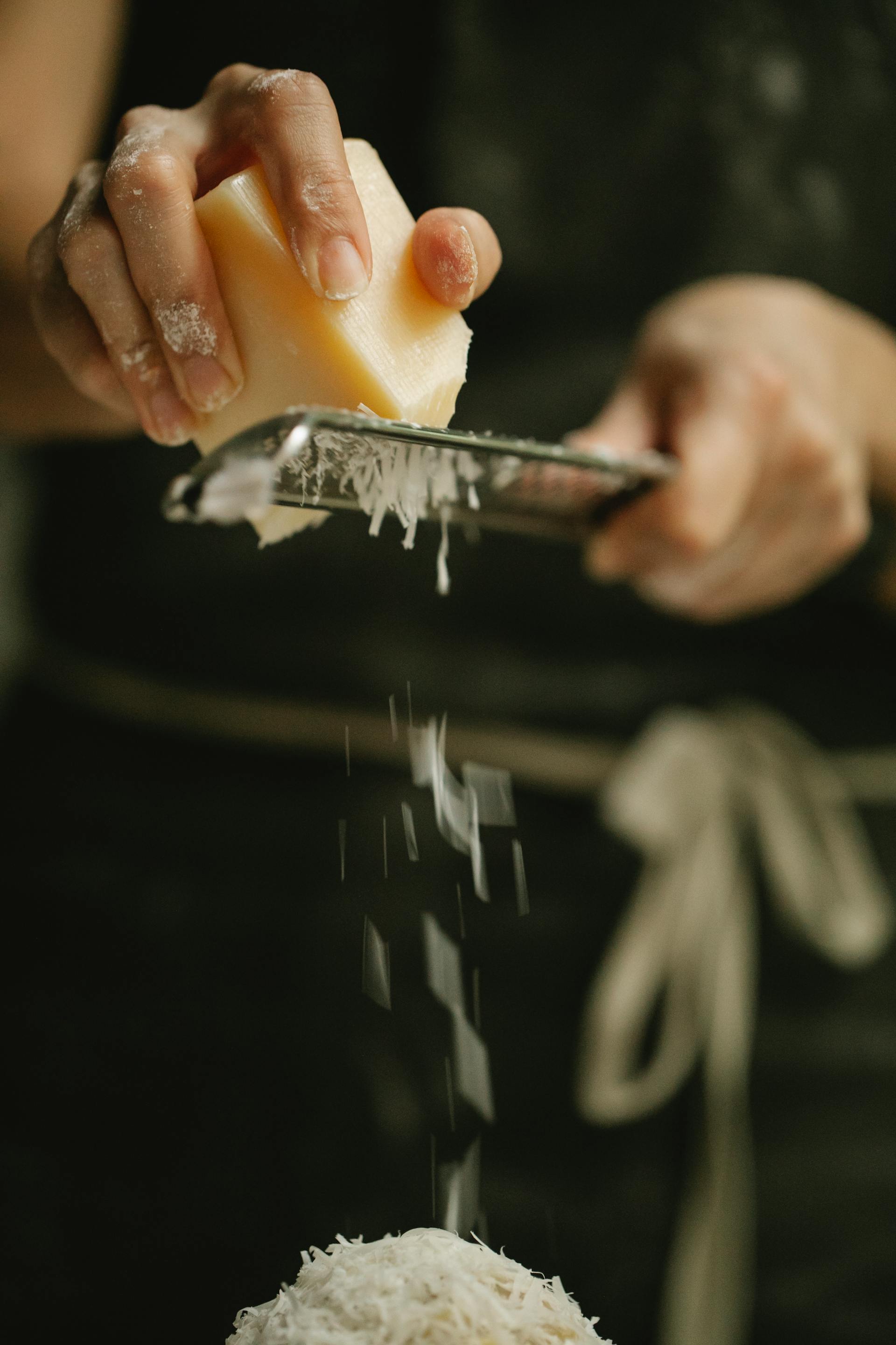 A person grating cheese | Source: Pexels