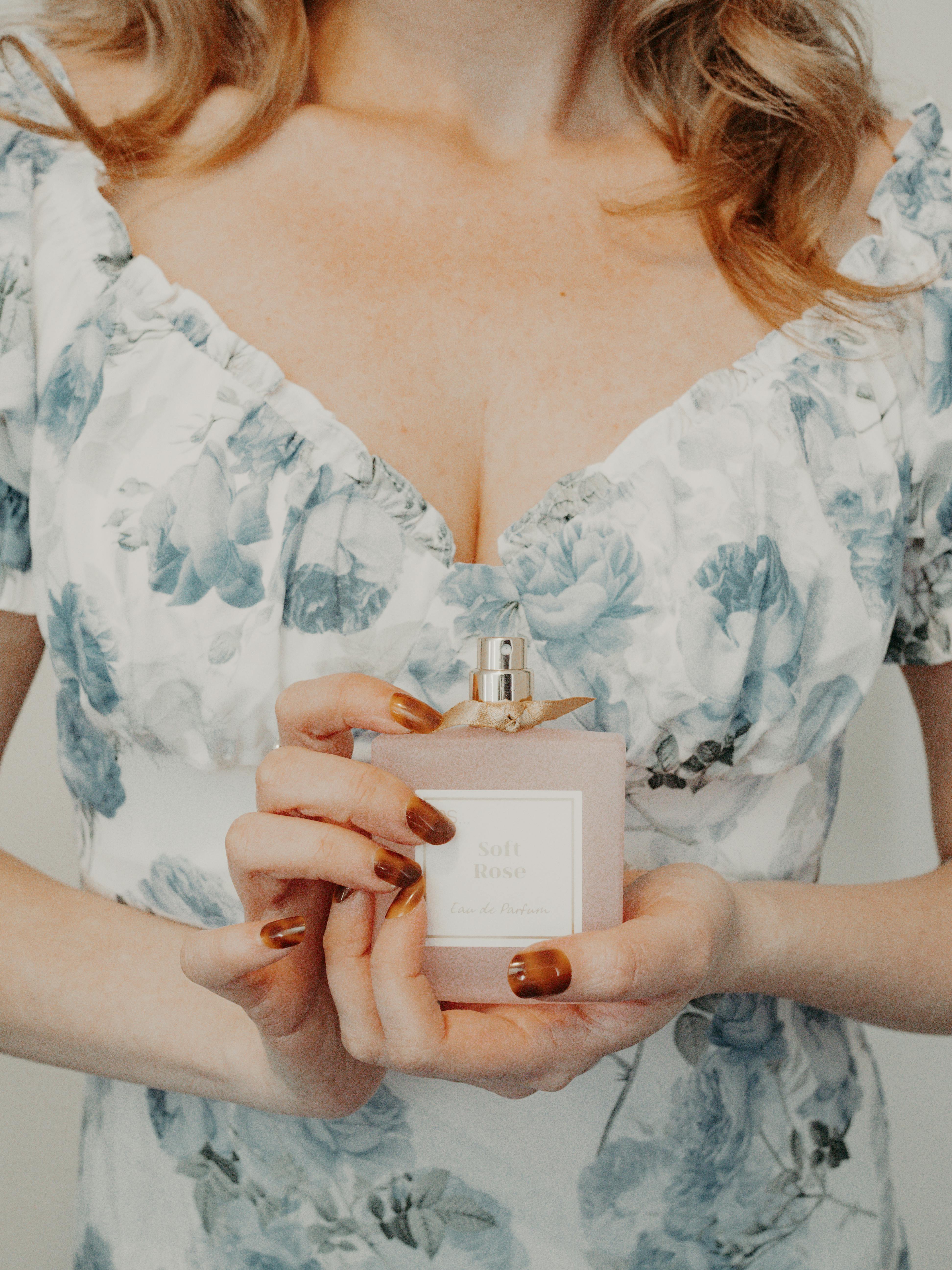 A woman holding onto her perfume bottle | Source: Pexels