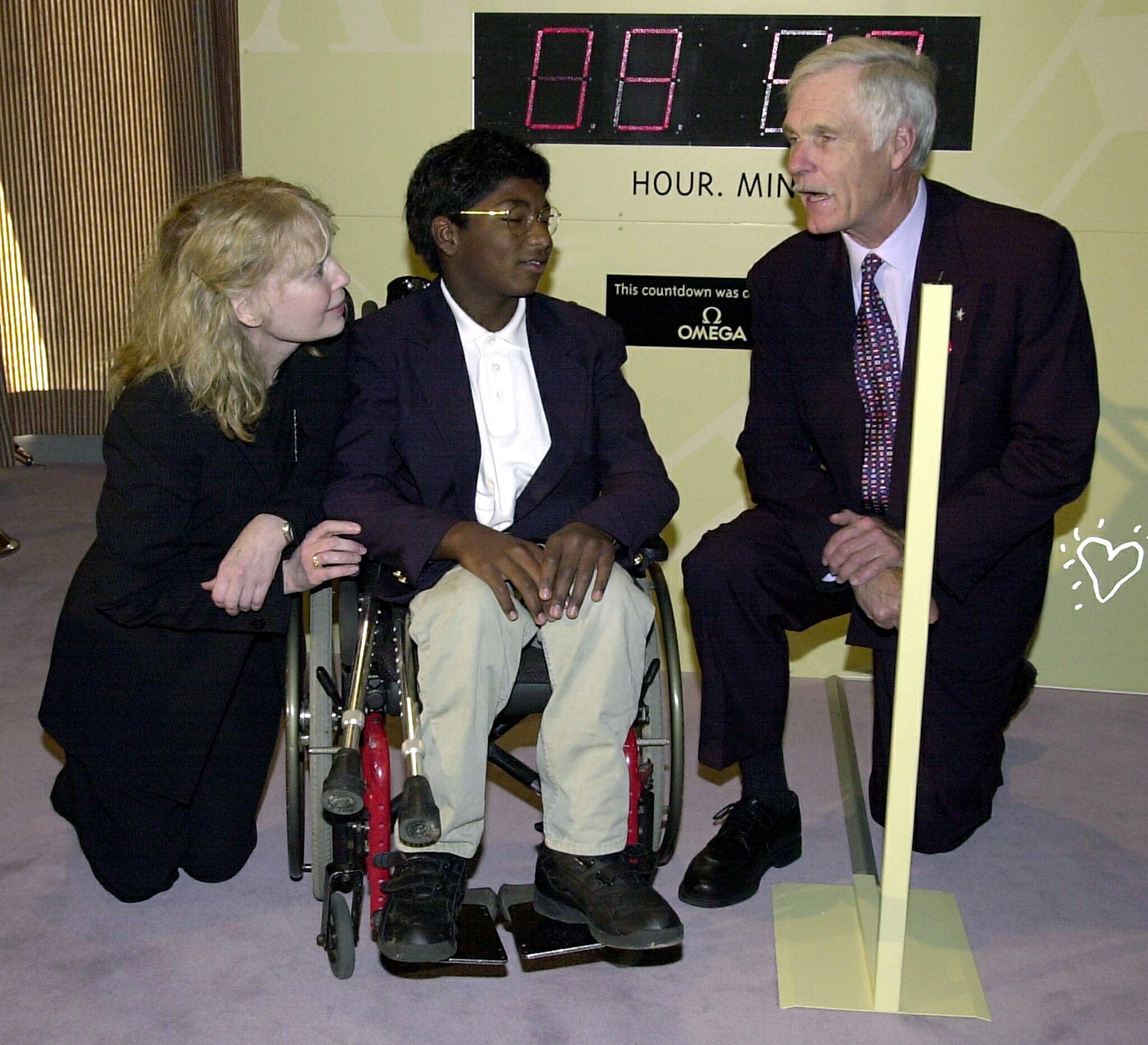 Mia Farrow and son Thaddeus, who suffers from polio, with media mogul Ted Turner at a United Nations conference on the eradication of polio in New York, in 2000. | Source: Getty Images
