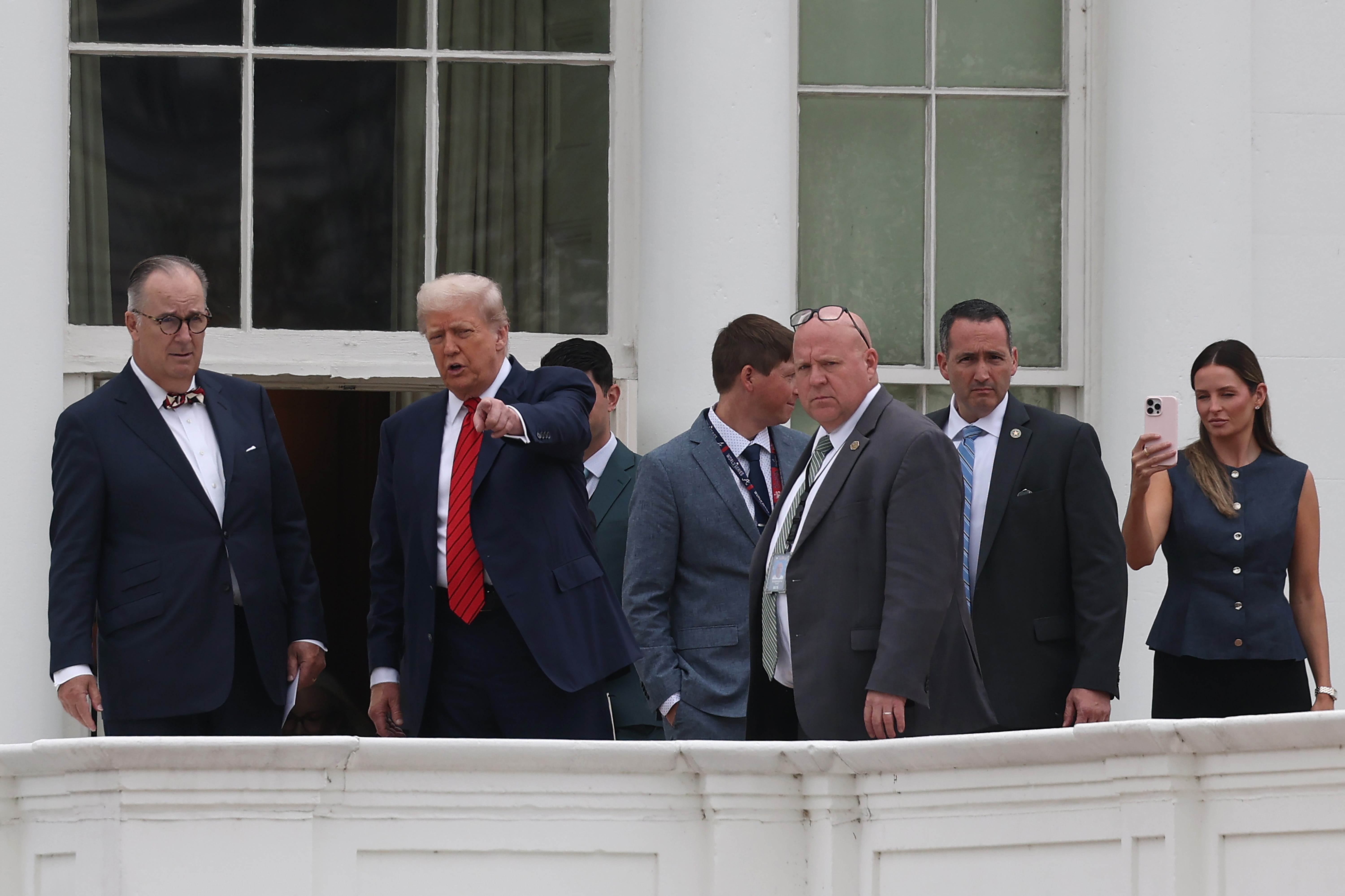 With an assertive gesture, Donald Trump speaks to staff and architect James C. McCrery on the White House roof in Washington, D.C., turning his unexpected visit into a memorable rooftop moment.