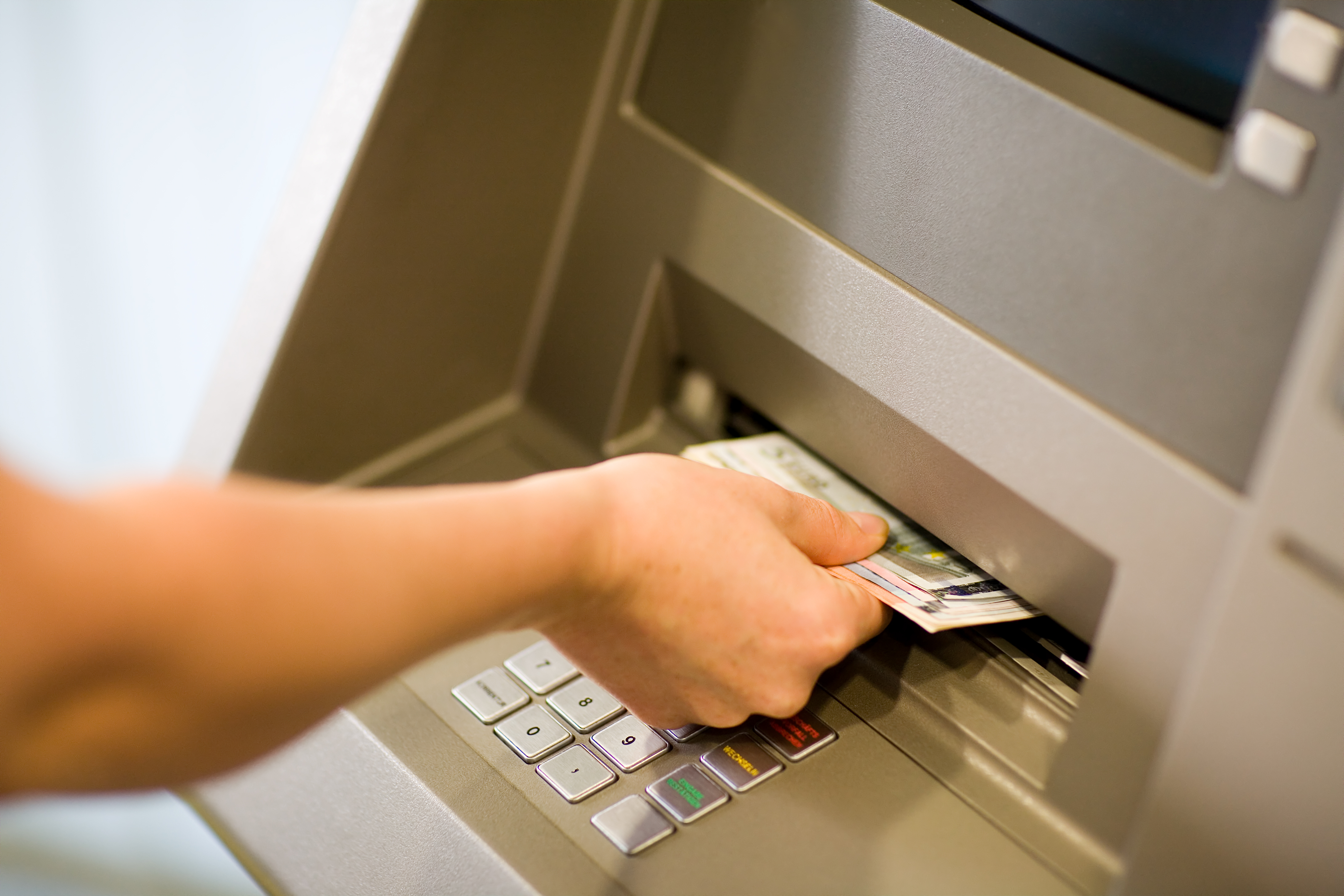 A person collecting money from an ATM. | Source: Shutterstock