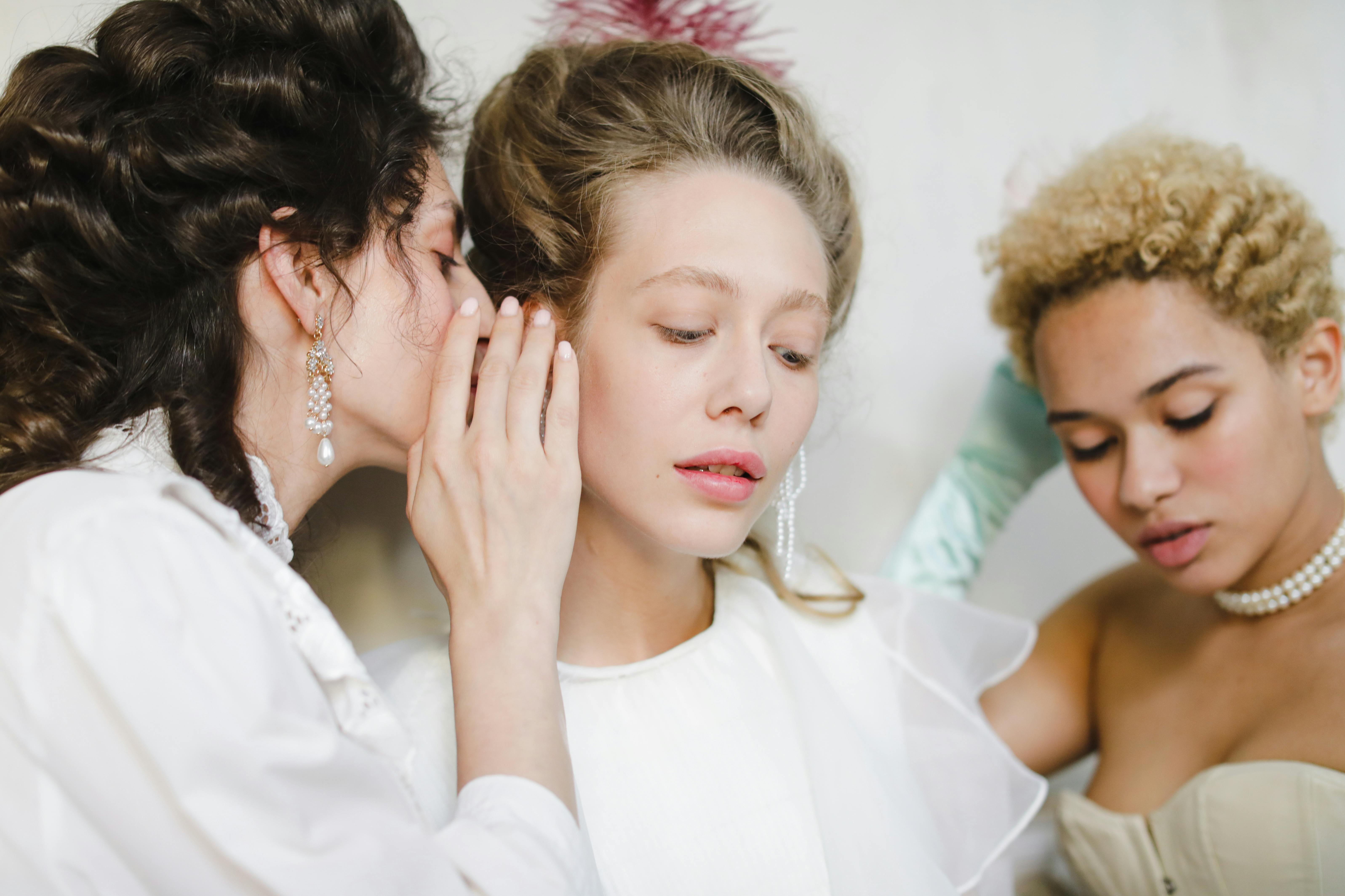 Women whispering at a wedding | Source: Pexels