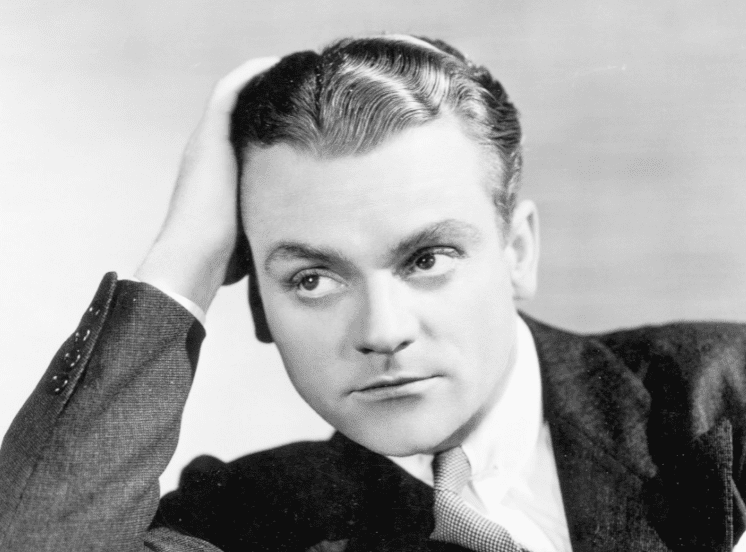 James Cagney leaning over the back of a chair, wearing a suit in the 1930s | Photo: Getty Images