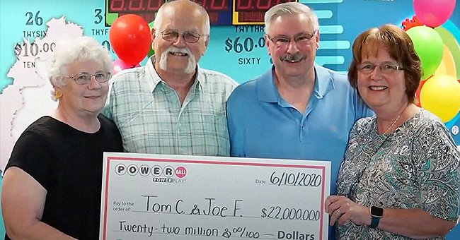 Thomas Cook and Joseph Feeney holding up placard along with their wives showing that they won the lottery. | Source: youtube.com/NBC News