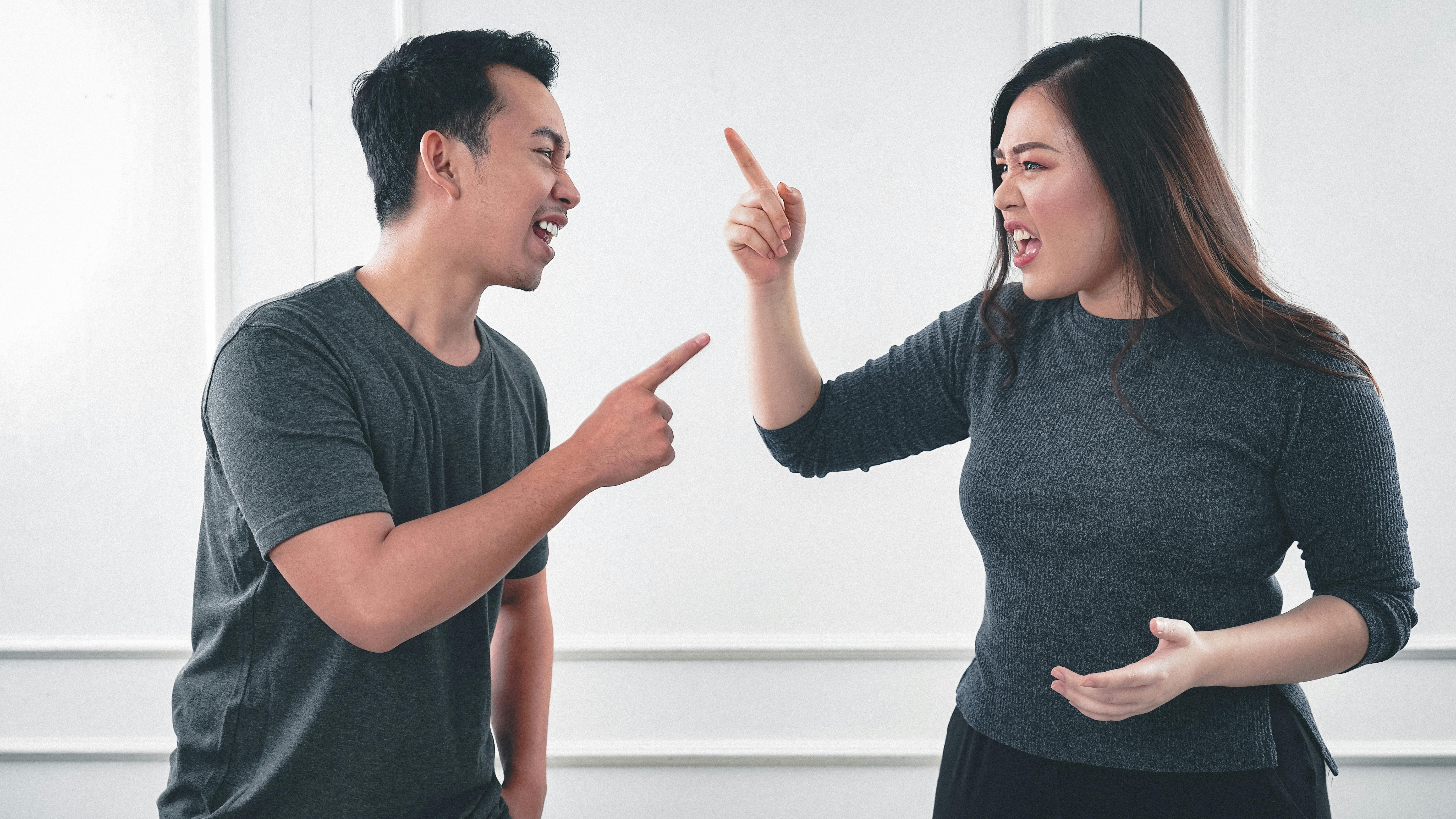 A man and a woman arguing while pointing fingers at each other | Source: Pexels