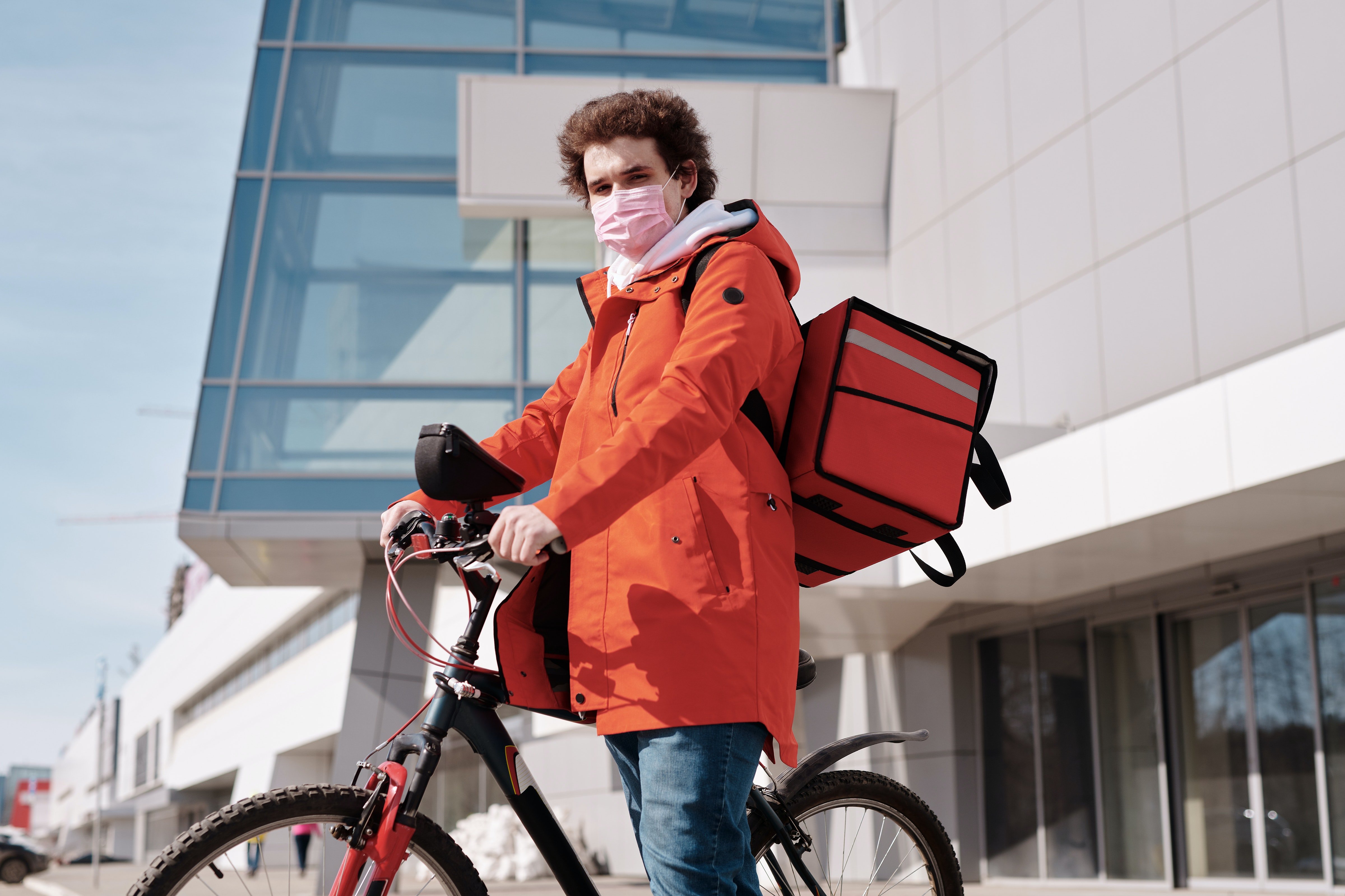 Delivery man wearing a face mask and riding a bicycle | Source: Pexels