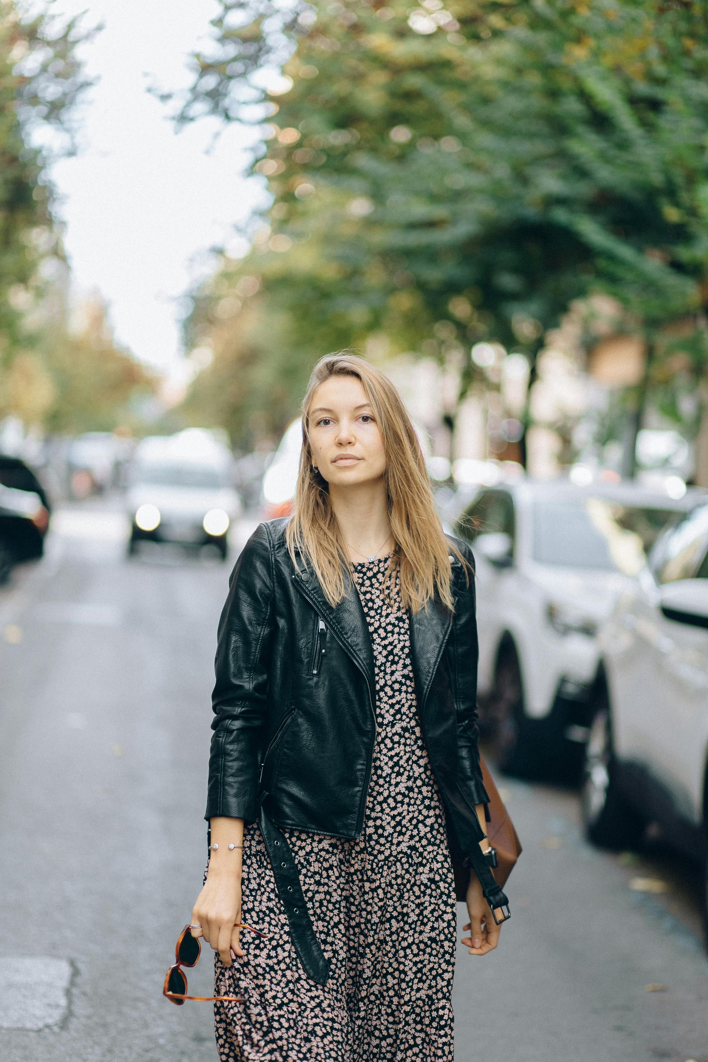 A woman accessorizing her dress with a leather jacket | Source: Pexels