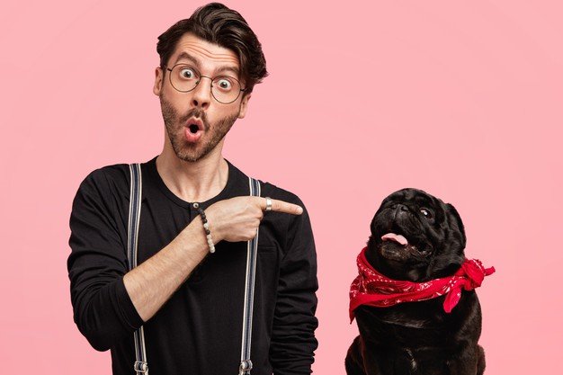 Hombre sorprendido señalando a su perro. │Foto: Freepik