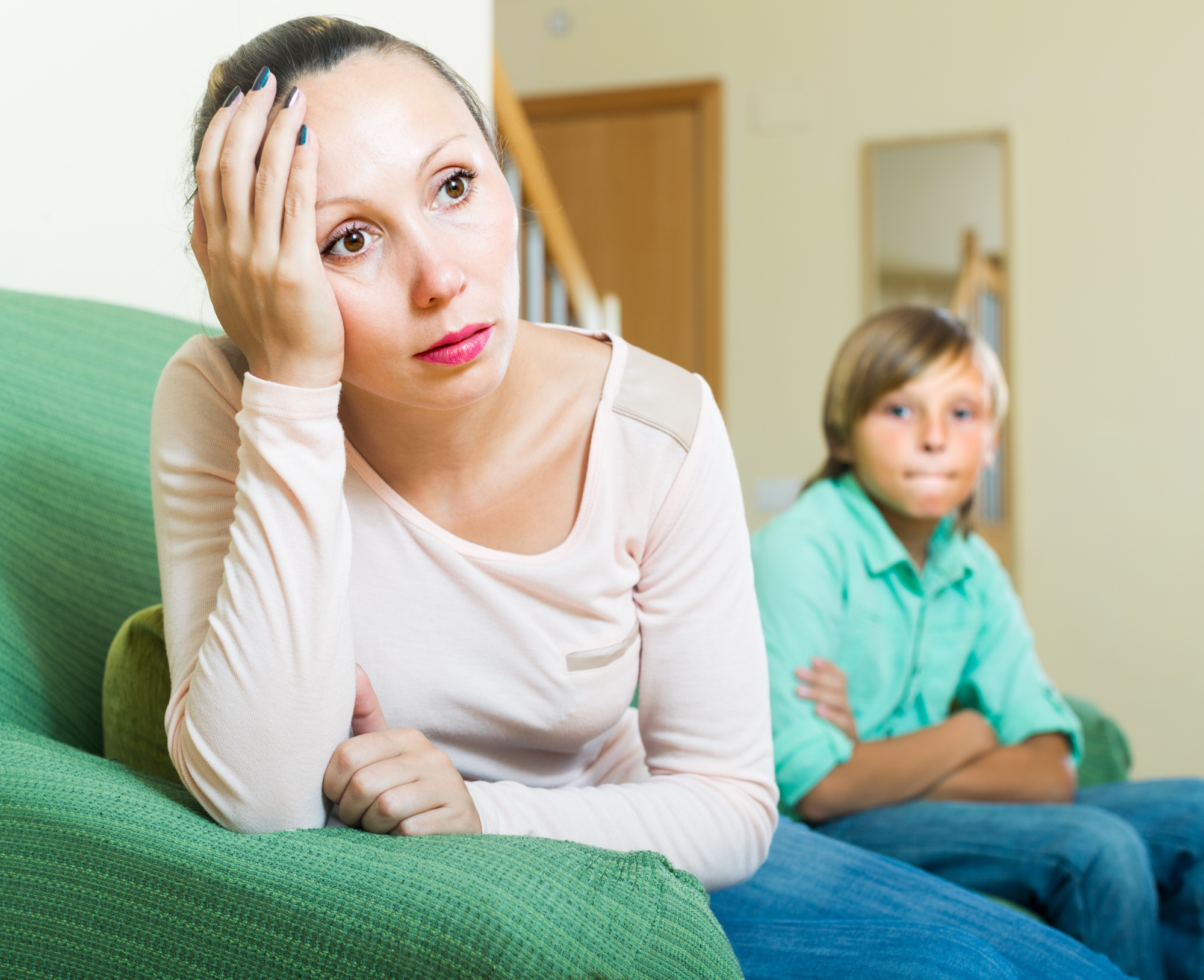 An upset mother sitting away from a defiant boy | Source: Freepik