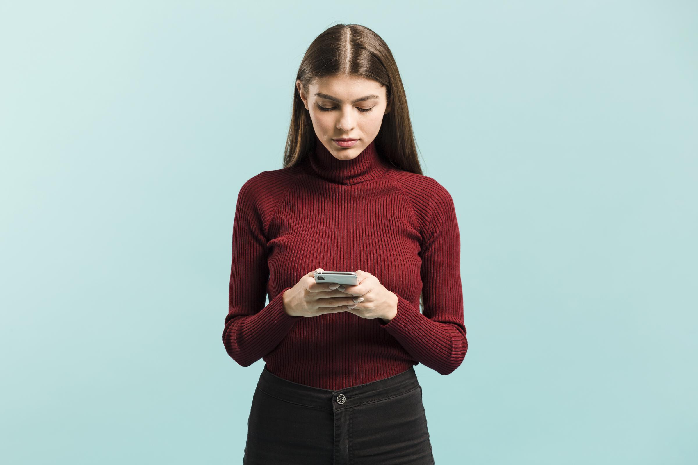 A young woman using her phone | Source: Freepik