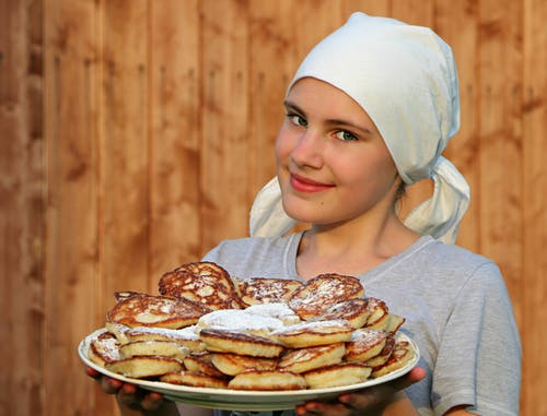 A cook holding a plate full of pancakes | Source: Pexels