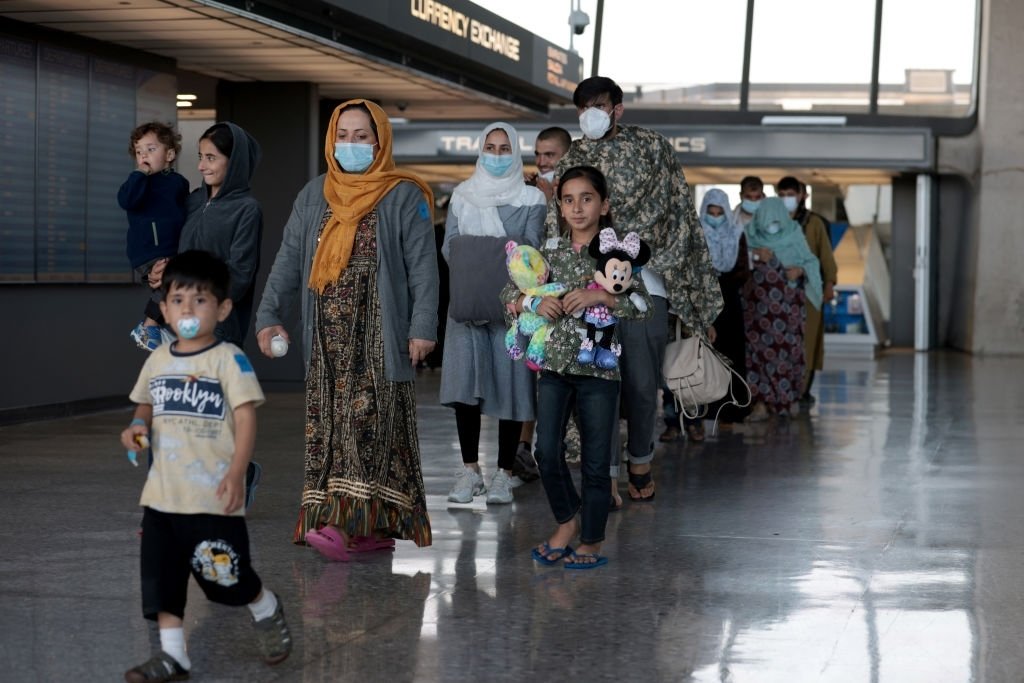 Une famille évacuée d'Afghanistan est conduite dans le terminal d'arrivée de l'aéroport international de Dulles. | Photo : Getty Images