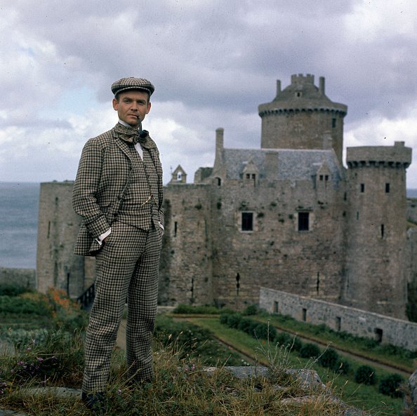 Philippe Ogouz, en costume de Rouletabille, se reposant devant le château fort du Cap Fréhel. | Photo : Getty Images