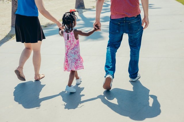 couple holding little girl's hand | Source: Pexels