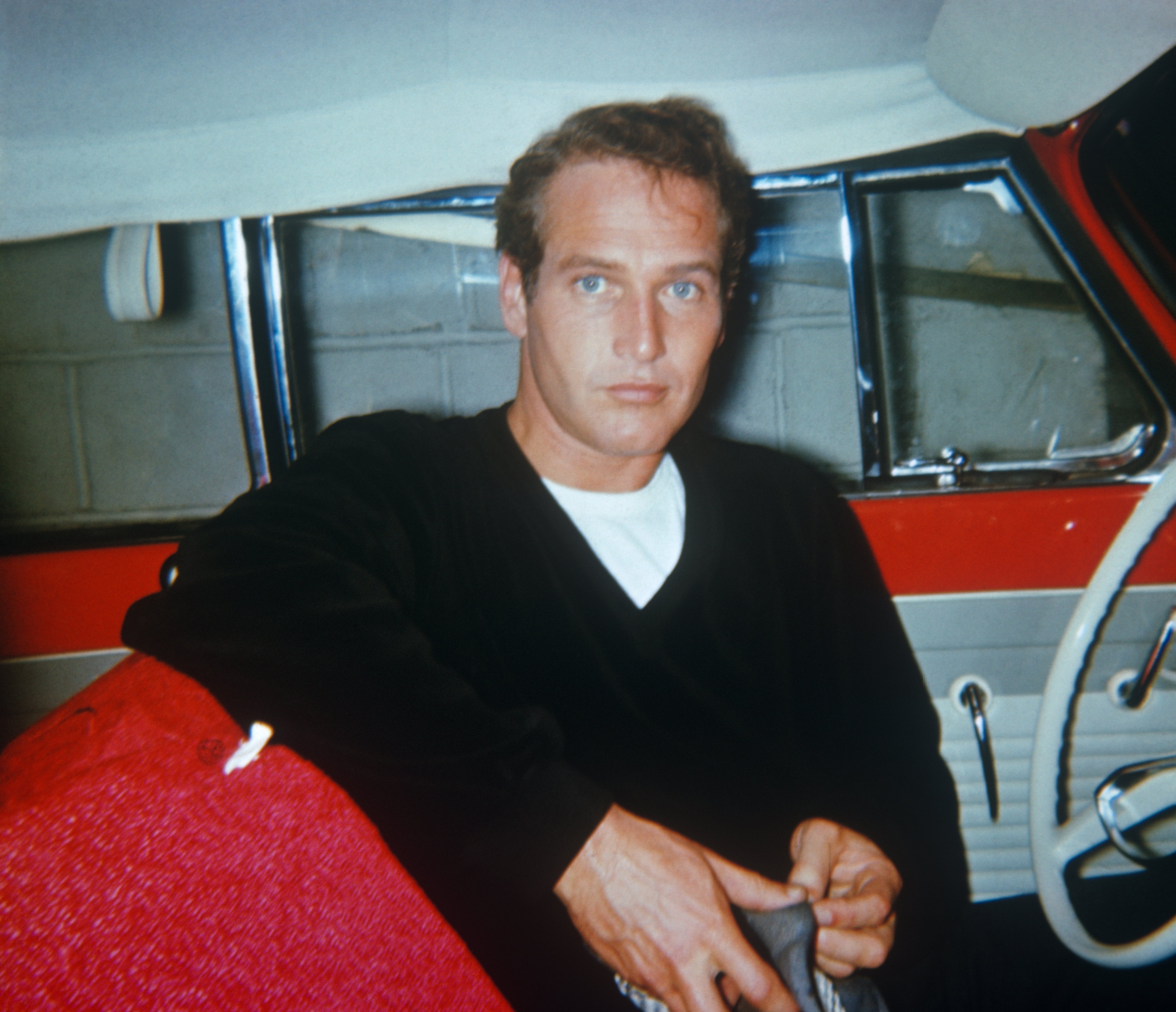 Paul Newman sitting in a red car with white interior, circa 1950. | Source: Getty Images