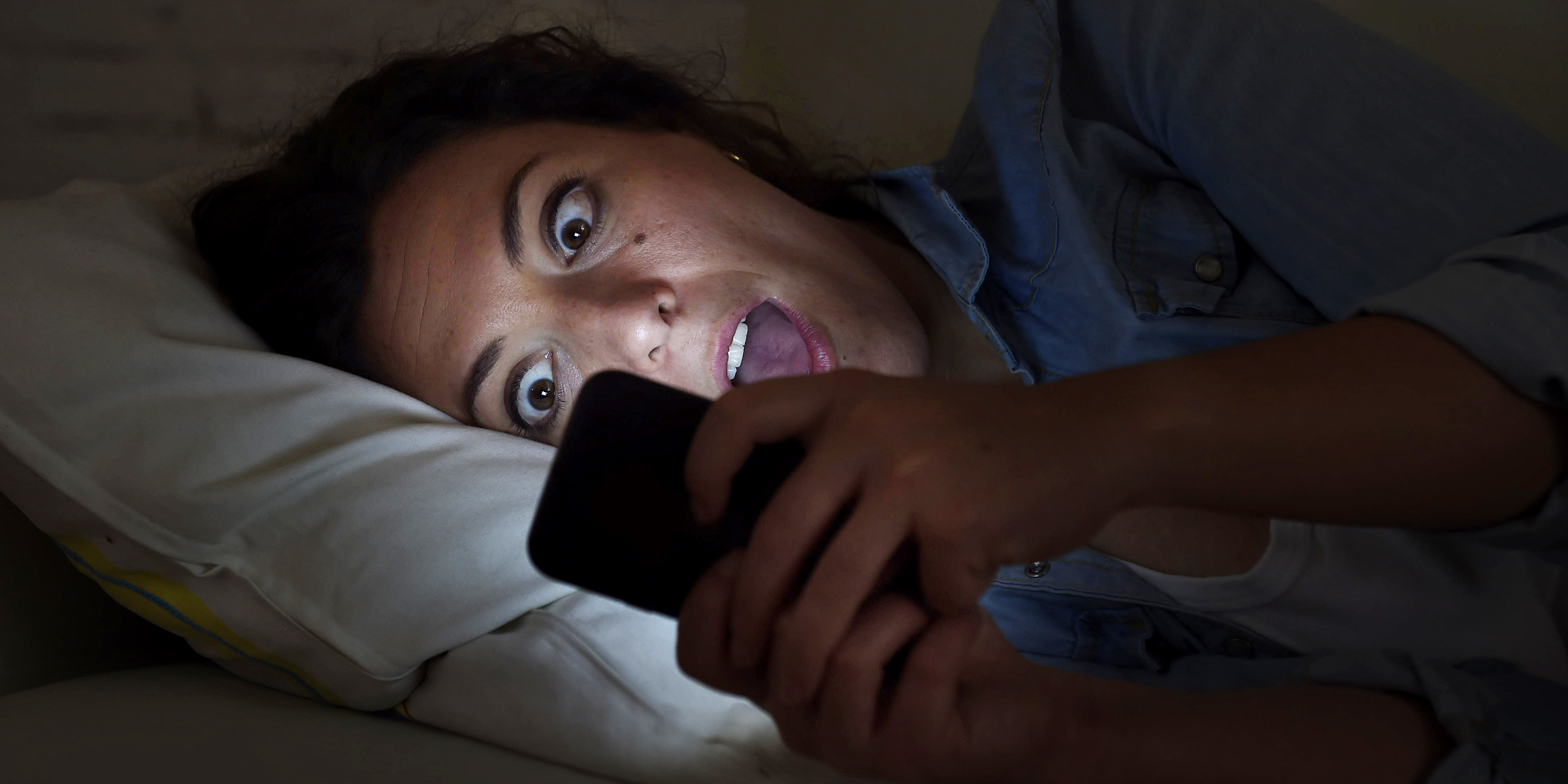 A woman reacting in shock to something on a phone | Source: Shutterstock