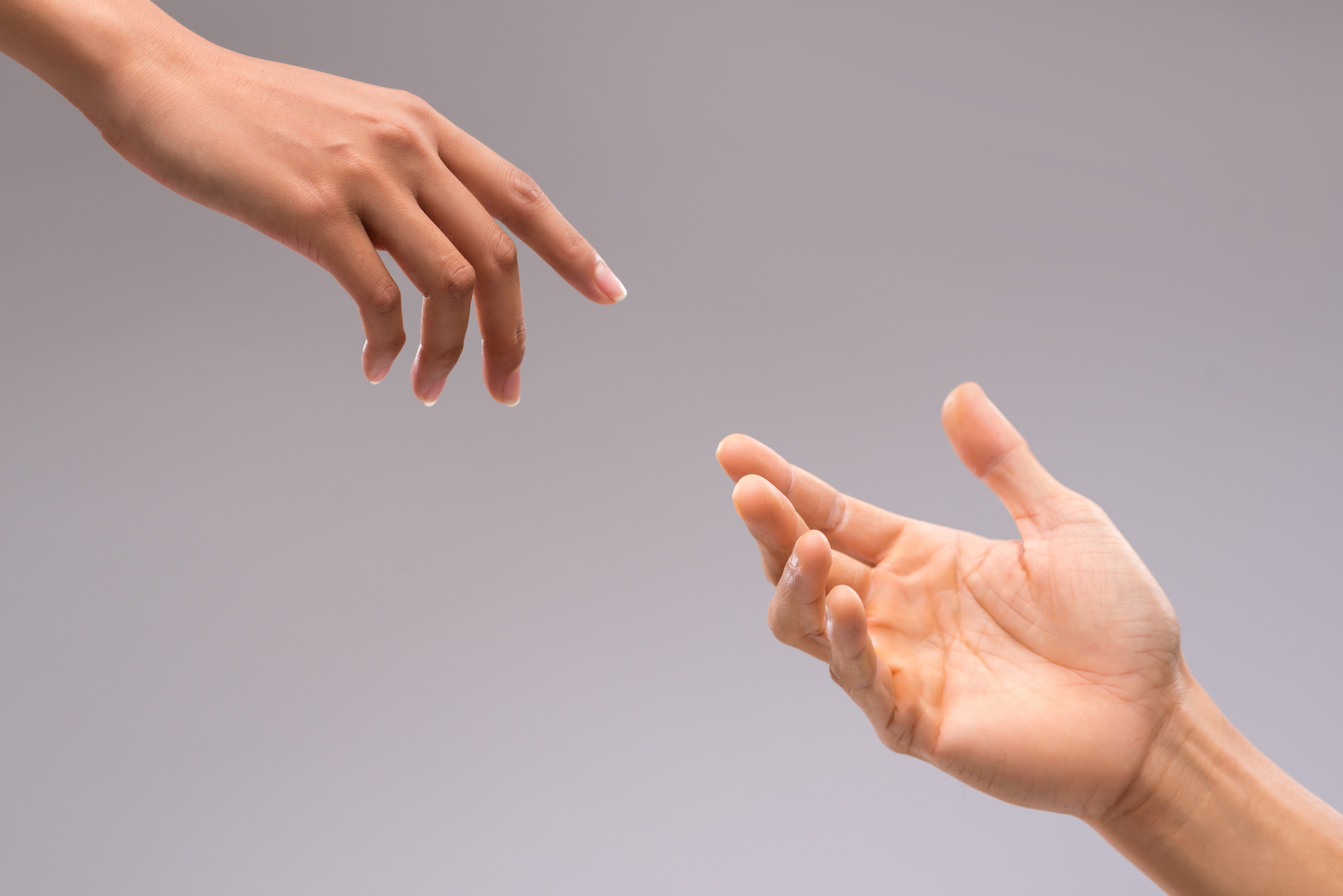 A woman and man's hand reaching for one another | Source: Shutterstock