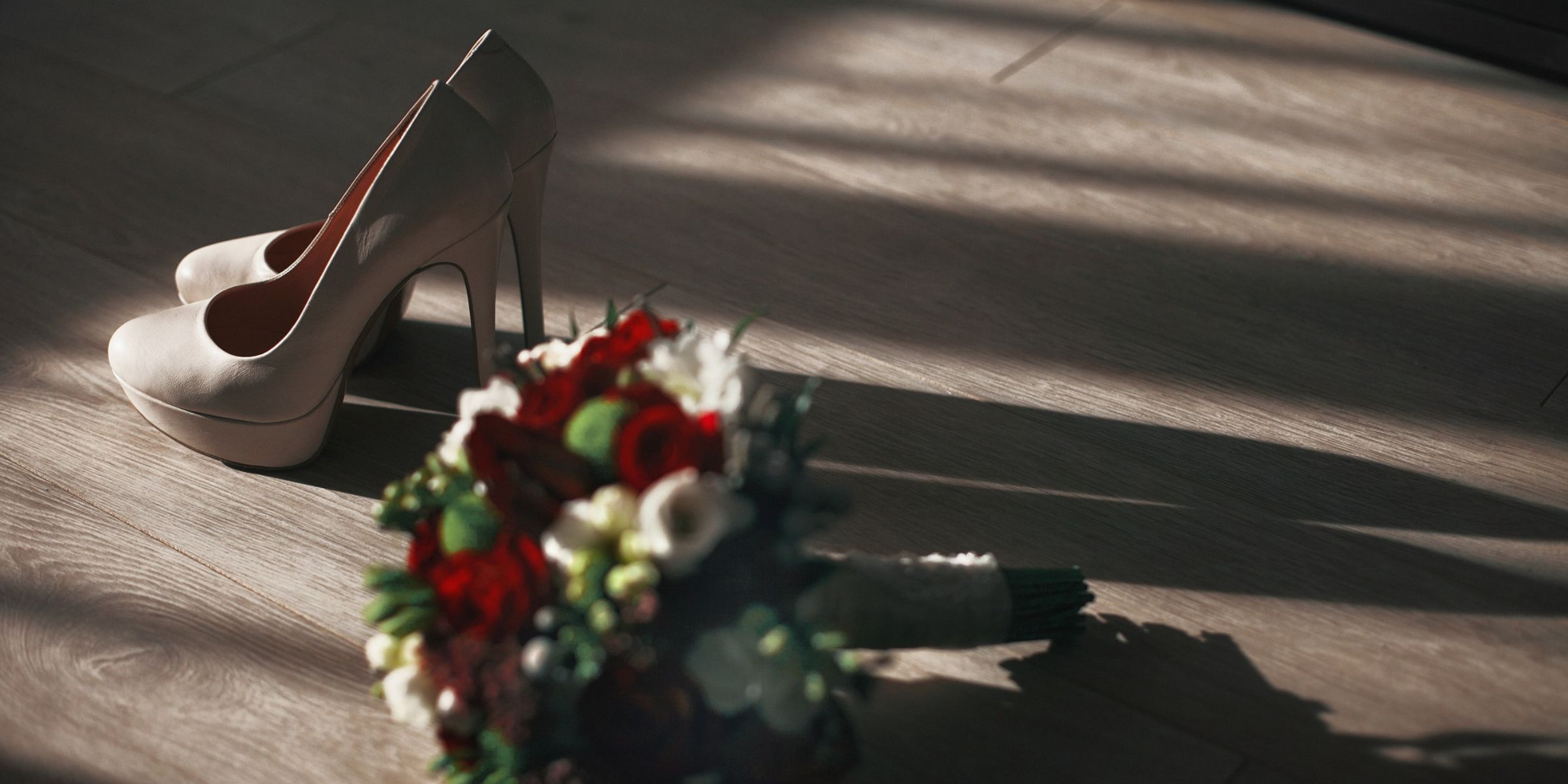 A wedding bouquet and white high heeled shoes on the floor | Source: Freepik