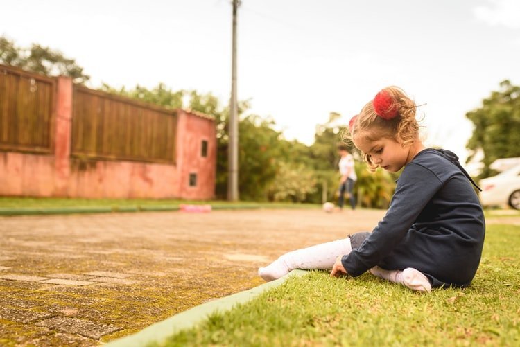 Une fille s'assoit au bord d'une ruelle. | Photo : Unsplash