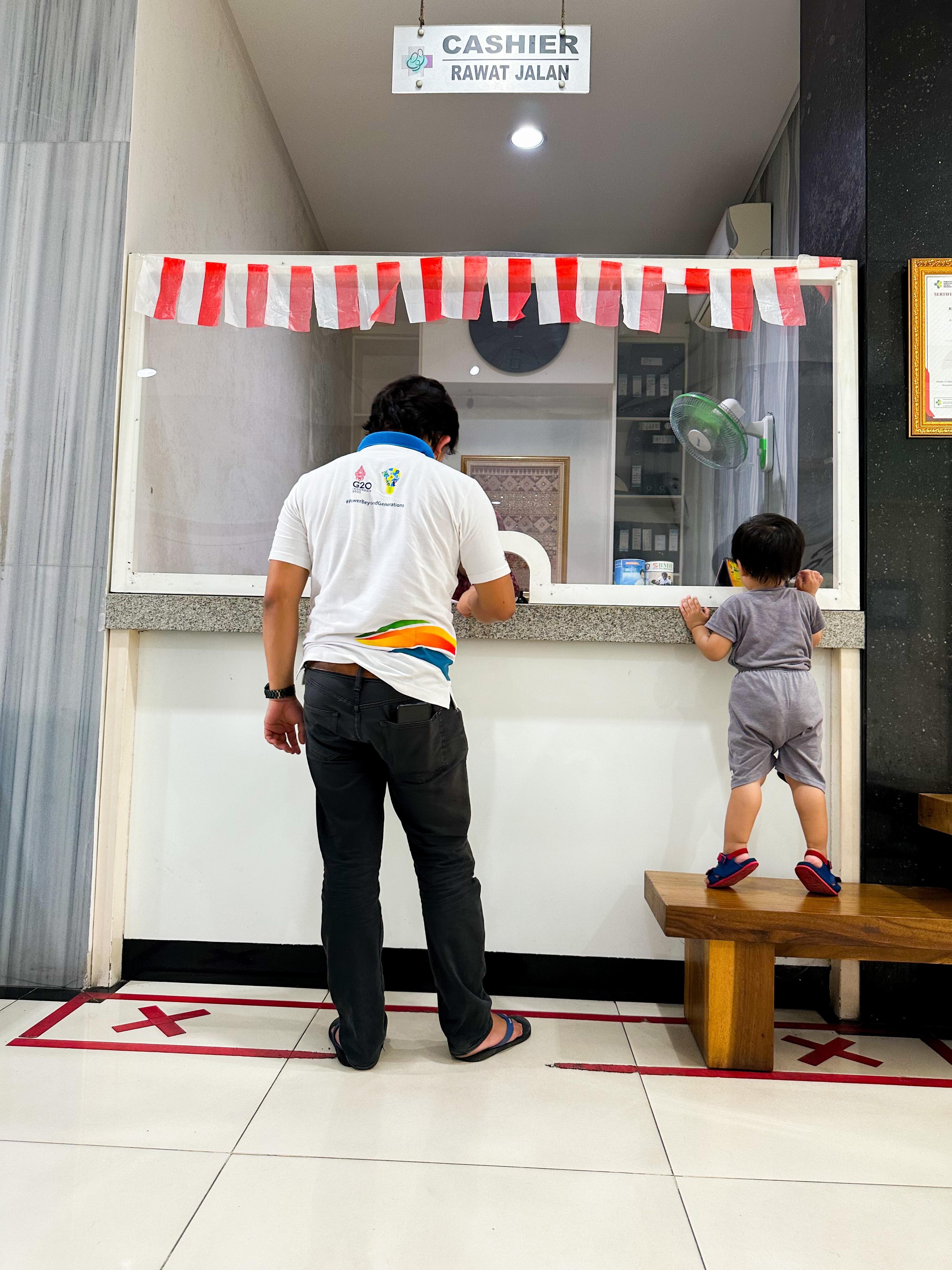 A man standing in front of the cashier with his kid | Source: Shutterstock