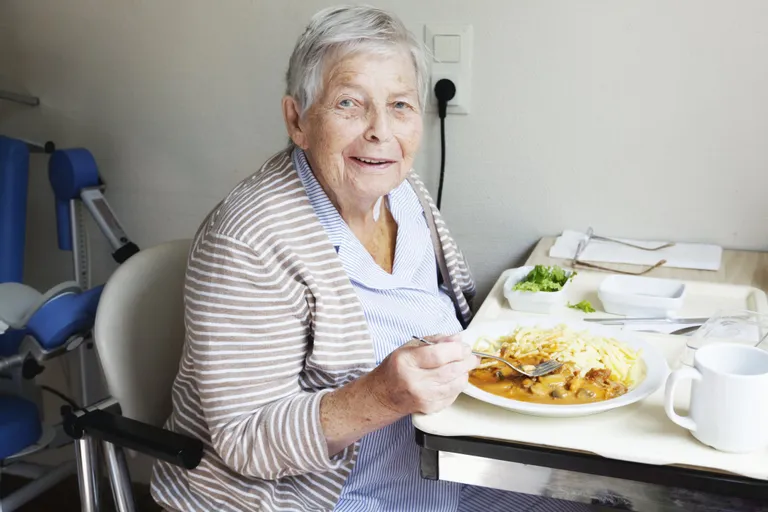 Une séniore heureuse de manger | source : Getty images