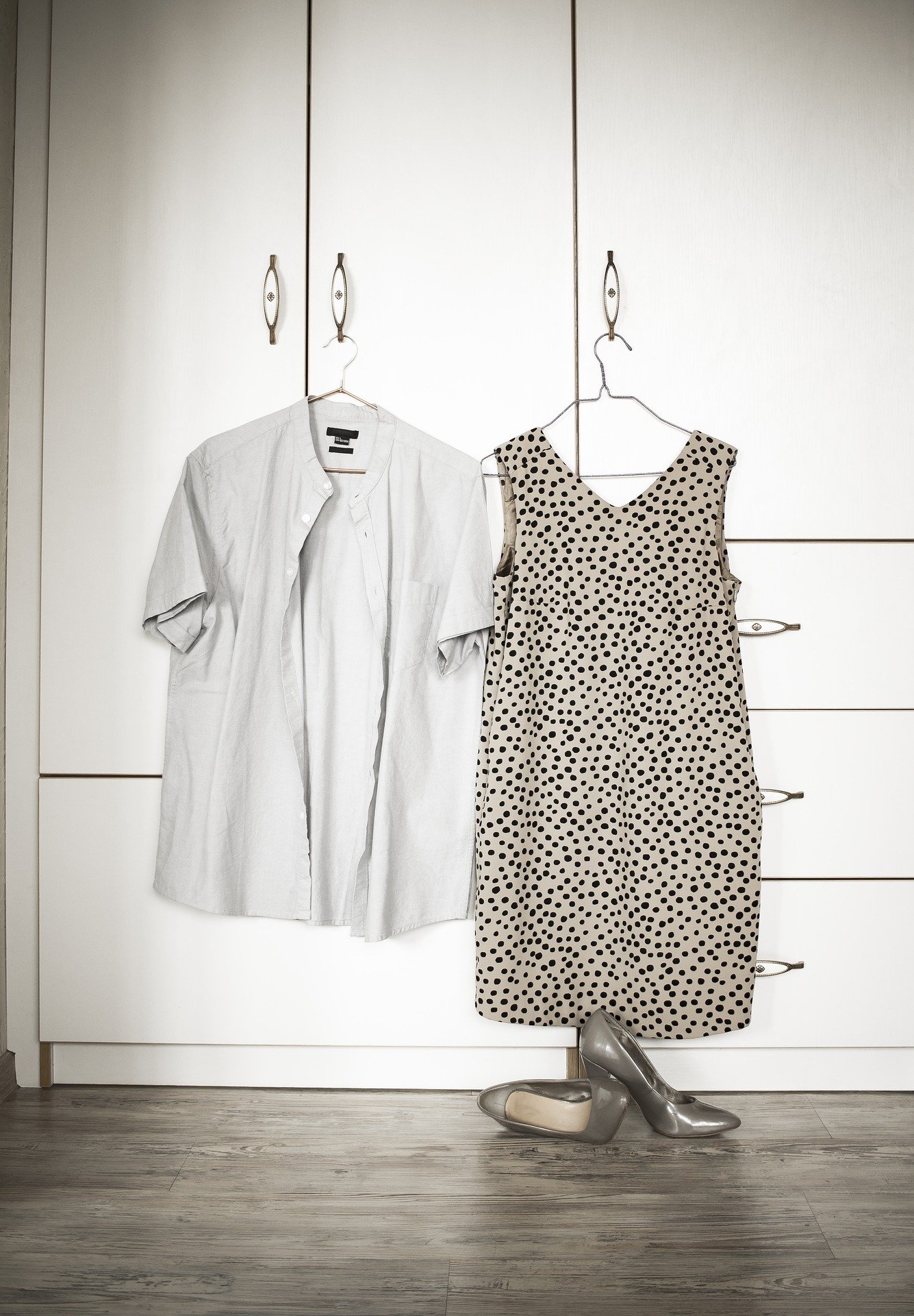 A shirt and a dress hung up outside a closed closet | Photo: Pixabay/Tatyana Gusarova