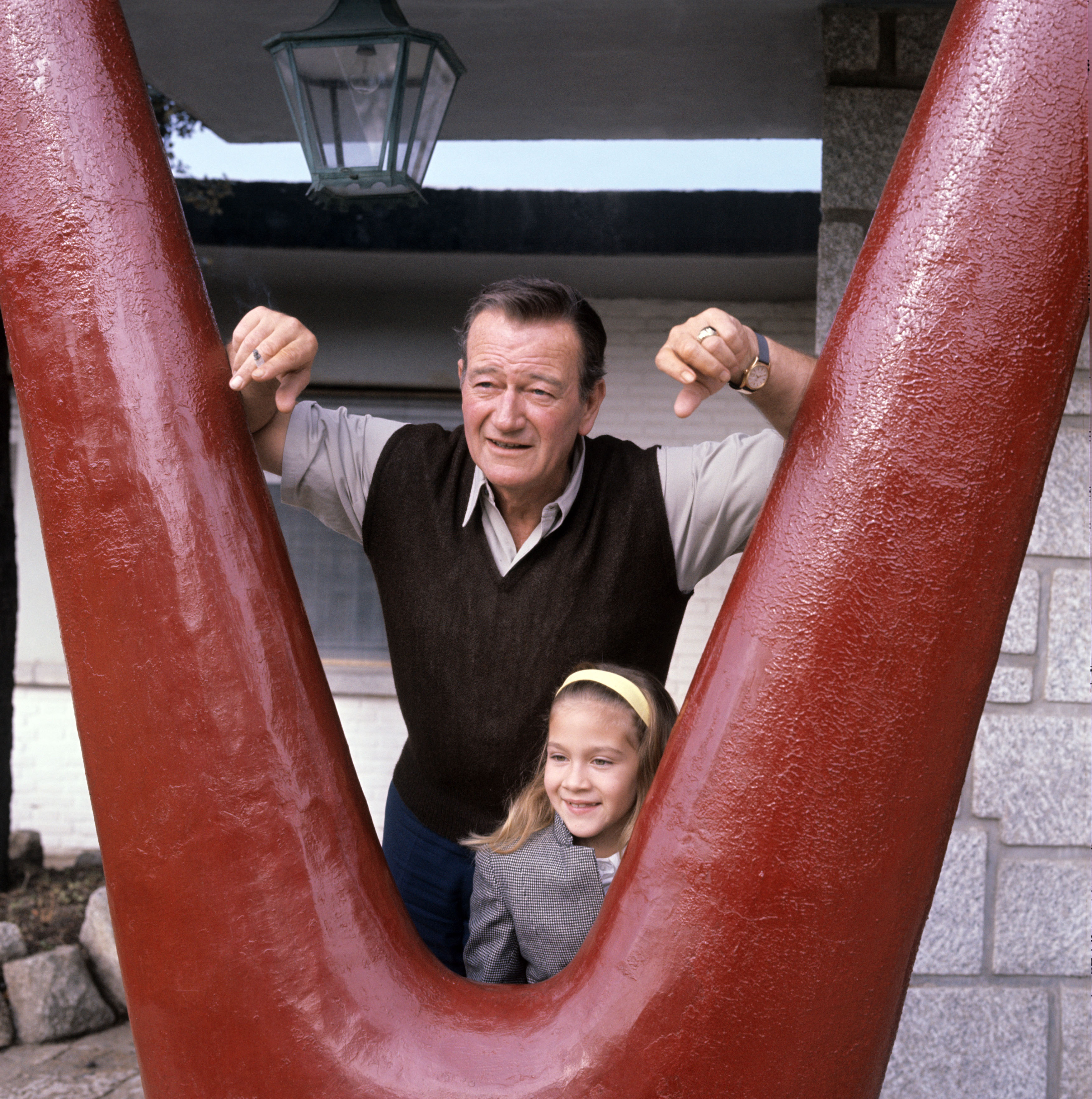 John Wayne and, Aissa Wayne, while shooting the film "In Harm's Way," circa 1965. | Source: Getty Images